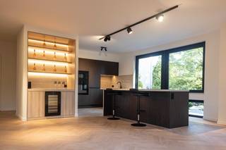 Exclusief wonen in stijl en comfort ✨<br /><br />Dit volledig gerenoveerde hoekappartement van 125 m² combineert ruimte, licht en luxe. De uitzonderlijke woonruimte van 60 m² wordt overspoeld door natuurlijk licht dankzij de vele ramen en straalt klasse uit met de eiken visgraat parketvloer, met de hand geolied, en een werkende open haard op bio-ethanol die voor extra sfeer zorgt.<br /><br />De luxueuze DSM-keuken met groot eiland vormt het hart van de leefruimte en sluit naadloos aan bij een stijlvol barmeubel met ingebouwde wijnkast. Het appartement telt drie ruime slaapkamers, waarvan de master voorzien is van airco. De badkamers zijn verfijnd afgewerkt met travertin in verstek gesneden.<br /><br />Daarnaast beschikt u over twee terrassen: vooraan met uitzicht op groen en open ruimte, en achteraan voor rust en privacy. Optioneel kan er een garagebox worden aangekocht (€25.000).<br /><br />Gelegen in een aantrekkelijke buurt, vlakbij winkels, restaurants en openbaar vervoer, combineert dit appartement licht, ruimte en luxe in een instapklare woning.<br /><br />Troeven:<br /><br />📐 125 m² totaal / 60 m² living<br /><br />🪟 Hoekappartement met veel ramen &amp; lichtinval<br /><br />🪵 Eiken visgraat parket, handgeolied<br /><br />🍽️ DSM-keuken met groot kookeiland<br /><br />🔥 Werkende open haard (bio-ethanol)<br /><br />🍷 Barmeubel met ingebouwde wijnkast<br /><br />🛏️ 3 ruime slaapkamers, master met airco<br /><br />🛁 Badkamers in travertin, verstek gesneden<br /><br />🌿 2 terrassen: vooraan met zicht op groen, achteraan rustig<br /><br />🚗 Garagebox optioneel bij te kopen (€25.000)