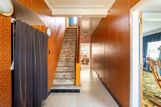 Deze grote, vrijstaande woning is gelegen vlakbij het centrum van het gezellige polderdorp Zandvliet. Hoewel de woning energetisch naar een beter niveau getild moet worden en een moderne, frisse wind het huis wellicht goed zou doen, is dit pand met haar zuid-tuin en prachtig perceel van 583m², een ruwe diamant die wacht om geslepen te worden. De woning heeft gigantisch veel mogelijkheden, mooie ruimtes en is bovendien erg goed gelegen! Binnenkomen doet u via de aparte, grote inkomhal. Verder heeft het gelijkvloers een grote leefruimte vooraan en 2 eetkamers en een praktische, nette keuken achteraan. Vanuit de keuken loopt u door naar het kleine badkamertje. Het halletje achter de eetkamer geeft toegang tot de grote, maar eenvoudige veranda, die uitkijkt over de tuin. Een apart gastentoilet is eveneens aanwezig op het gelijkvloers. De houten trap in de inkomhal brengt u naar de eerste verdieping, waar u bovenkomt in een grote nachthal. Deze geeft toegang tot 2 gigantische slaapkamers van maar liefst 16m² en een kleinere, derde slaapkamer. De mogelijkheid bestaat een volwaardige trap naar de zolderverdieping te installeren en deze volledig naar eigen wens te benutten! Het dak van de woning werd 10 jaar geleden volledig vernieuwd en geïsoleerd. Verder kan u beschikken over een grote garage die vanuit de woning toegankelijk is. Deze biedt ruimschoots plaats aan uw wagen en doet eveneens dienst als wasplaats. Ook de grote, hoge en kurkdroge kelder is een tof extraatje.