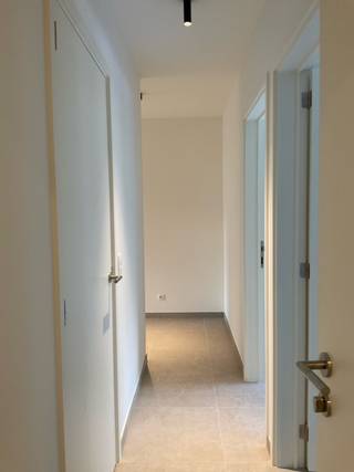 Het appartement omvat volgende ruimtes: Ruime leefruimte met volledig uitgeruste keuken en aansluitende bergruimte, 2 slaapkamers, badkamer (met douche, badkamermeubel, sommige met toilet/ligbad), apart toilet, terras. Buiten het gebouw is een afgesloten bergkast voorzien voor afval. 1 autostaanplaats nr. 1 achteraan het gebouw is inbegrepen in de prijs.