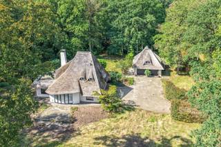 Verscholen in het groen, op een prachtig perceel van maar liefst 9.633 m², bevindt zich deze gerenoveerde villa met karakteristiek rieten dak. Een bijzondere eigendom waar rust, ruimte en privacy centraal staan, gecombineerd met een lichtrijk interieur en tal van mogelijkheden, waaronder kangoeroewonen.<br /><br />Via de ruime oprit bereikt u de woning en de twee garages. Binnen vormt de royale leefruimte het hart van de villa. De vele glaspartijen zorgen voor een overvloed aan natuurlijk licht en bieden een aangenaam zicht op het omliggende groen. Aansluitend bevindt zich een volledig uitgeruste keuken, voorzien van alle nodige toestellen. Verder beschikt het gelijkvloers over een afzonderlijke bureauruimte en een slaapkamer met eigen badkamer, waardoor comfortabel gelijkvloers wonen perfect mogelijk is.<br /><br />Op de eerste verdieping springt meteen het gevoel van ruimte in het oog. De hoge plafonds met zichtbare balken versterken het karakter van de woning. De royale hoofdslaapkamer geeft rechtstreeks toegang tot een dakterras, waar u in alle rust van de groene omgeving geniet. Daarnaast bevindt zich hier een tweede slaapkamer met doorloopdressing en een ruime tweede badkamer, uitgerust met dubbele wastafel, ligbad en douche.<br /><br />Een bijzondere troef is de ruime, afzonderlijk bereikbare ruimte boven de garage, toegankelijk via een buitentrap. Hier worden momenteel voorzieningen getroffen voor een eigen keuken en badkamer. Dankzij de afzonderlijke toegang en de royale oppervlakte biedt deze ruimte tal van mogelijkheden, bijvoorbeeld als gastenverblijf of zelfstandige woon-/werkruimte.<br /><br />Buiten geniet u vooral van één ding: groen, en dat zover het oog reikt. Het uitzonderlijk ruime perceel van bijna één hectare biedt volop privacy en maakt van deze woning een heerlijke plek voor wie landelijk en rustig wil wonen.<br /><br />Een belangrijke bijkomende troef is het recent volledig vernieuwde dak. De woning wordt verwarmd op gas en beschikt over een EPC-label C.<br /><br />Contacteer Vincent voor een bezoek ter plaatse via Vincent@reds.be of 0475 21 00 86.