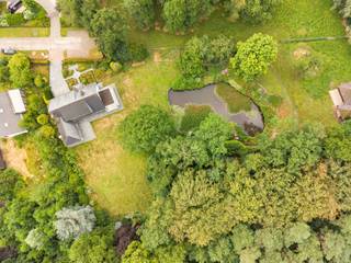 Charmante villa met ruime uitbreidingsmogelijkheden op een uniek privé-domein grenzend aan natuurgebied te Schilde<br /><br />In één van de meest gegeerde en residentiële buurten van Schilde, discreet gelegen aan het einde van een doodlopende straat, bevindt zich deze karaktervolle villa op een uitzonderlijk perceel van ca. 14.990 m², waarvan een deel ingericht werd voor het houden van dieren met eigen verblijf. Een locatie waar rust, privacy, natuurbeleving en comfort naadloos samenkomen.<br /><br />Indeling gelijkvloers:<br />De villa verwelkomt u via een ruime en lichtrijke inkomhal met vestiaire en gastentoilet. Vanuit hier bereikt u de aangename leefruimte met open haard en grote raampartijen, die zorgen voor een prachtig uitzicht op de fraai aangelegde tuin. Aansluitend bevindt zich een sfeervolle leefveranda, volledig omringd door schuiframen en voorzien van automatische zonnescreens, zodat u het hele jaar door geniet van een maximale lichtinval en een harmonieus zicht op het groen.<br /><br />De volledig uitgeruste keuken biedt eveneens zicht op en directe toegang tot het terras en wordt vergezeld door een praktische berging. Aansluitend bevindt zich een tweede gezellige leef- en eetruimte, voorzien van een houtkachel, wat deze ruimte bijzonder warm en uitnodigend maakt. Tevens is er een aparte bureauruimte, ideaal voor wie praktijk- of kantooractiviteiten aan huis wenst. De inpandige garage met automatische poort biedt plaats aan twee voertuigen.<br /><br />Eerste verdieping:<br />De nachthal leidt naar de master bedroom met ensuite badkamer, aangevuld met drie comfortabele, volwaardige slaapkamers. Daarnaast is er een tweede badkamer met douche en een bijzonder ruime, functionele wasplaats.<br /><br />Tuin en buitenbeleving:<br />De zuidwest-georiënteerde parktuin vormt een ware oase van rust, met weidse vergezichten en een bijzonder harmonieuze groenbeleving. De tuin werd smaakvol aangelegd, inclusief een fraaie vijverpartij, en beschikt bovendien over een bijgebouw/stal voor het houden van dieren — ideaal voor paarden- of dierenliefhebbers, of voor wie een hobbyproject wenst te realiseren.<br /><br />Bijzonderheden:<br />- Maximale privacy, prestigieuze ligging & ideale zonoriëntatie<br />- Renovaties: 1997 (aanbouw leefruimte) – 1999 (gedeeltelijk buitenschrijnwerk)<br />- Verwarming op aardgas (Viessmann) via radiatoren en convectoren<br />- Dubbele beglazing (hout & aluminium)<br />- Rolluiken aanwezig<br />- Videofonie & automatische toegangspoort<br />- Oprit met plaats voor ca. 6 wagens<br />- Bergzolder toegankelijk via vlizotrap