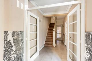 <p>TE KOOP - GENT<br /><br />Voor meer informatie of om een afspraak te maken, contacteer Bruno via 0495 12 20 64.</p>
<p>Dit karaktervolle herenhuis uit 1934 werd ontworpen door architect Charles Hoge. Het pand ligt in de Tentoonstellingslaan 51, vlak bij het Muinkpark, en combineert historische allure met recente energetische ingrepen.</p>
<p>Met deze ligging, in de nabijheid van belangrijke uitvalswegen en met openbaar vervoer voor de deur, treft u de ideale combinatie van wooncomfort en bereikbaarheid. Winkels, gezellige restaurants en het historische stadscentrum liggen op wandelafstand.</p>
<p>Op het gelijkvloers vindt u een functionele keuken met veel bergruimte, een ruime eetplaats, een toilet, inbouwkasten en een buitenruimte. De bel-etage biedt een lichtrijke leefruimte met visgraatparket en een slaapkamer met badkamer, voorzien van douche en ligbad. Op de tweede verdieping liggen twee grote slaapkamers en een badkamer, eventueel te gebruiken als wasplaats. De derde verdieping telt twee slaapkamers en toegang tot de kruipzolder. De woning is volledig onderkelderd. Recent werden de ramen en de voordeur vernieuwd, de achtergevel volledig geïsoleerd en de verwarming vervangen. Het pand is asbestveilig en de elektriciteit is conform.</p>
<p>Een unieke kans: karakter, ruimte en comfort in een architecturaal sterk herenhuis aan het Muinkpark.<br /><br />Alle beschikbare documenten kunt u terugvinden op onze website.</p>
