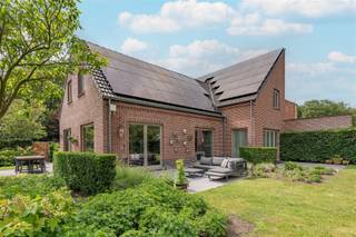 <p>Midden in het groen en omgeven door absolute rust, bevindt zich deze uitzonderlijke eigendom op een perceel van maar liefst 1.806 m². Hier gaan ruimte, privacy, wooncomfort en vooruitstrevende energietechnologie hand in hand.</p><p>Deze perfect onderhouden duo-woning uit 2013 biedt een bewoonbare oppervlakte van ca. 268 m² en onderscheidt zich door haar hoogwaardige afwerking, overvloedige lichtinval en doordachte indeling. Grote raampartijen creëren een prachtige verbinding met de fraai aangelegde tuin en laten u vanuit vrijwel elke leefruimte genieten van het omliggende groen.</p><p>Het hart van de woning wordt gevormd door de ruime leefkeuken met aansluitende woon- en eetruimte, waar gezelligheid en functionaliteit centraal staan. Verder beschikt de woning over vier volwaardige slaapkamers, twee badkamers, een inloopdressing en diverse multifunctionele ruimtes die perfect inspelen op de noden van een modern gezin.</p><p>Een extra troef is de volledig geïntegreerde woonunit van ongeveer 70 m², ideaal als gastenverblijf, thuiskantoor, praktijkruimte of voor inwonende familie. Deze veelzijdige ruimte maakt de woning bijzonder toekomstgericht.</p><p>Ook buiten wordt niets aan het toeval overgelaten. De zuidoost georiënteerde tuin biedt maximale privacy en optimale bezonning. Meerdere terrassen, een carport voor 3 wagens met fietsenberging en multifunctioneel bijgebouw anex garage gebouw, dewelke bereikbaar is via een private toegangsweg rechts van het perceel, zorgen voor een uitzonderlijk gebruikscomfort.</p><p>Op energetisch vlak behoort deze eigendom tot de absolute top. Met een zonnepaneleninstallatie van ca. 27 kWp/ 159 zonnepanelen, en EPC label A+++ geniet u van bijzonder lage energiekosten en maximale energie-onafhankelijkheid.</p><p>Een unieke opportuniteit voor wie op zoek is naar exclusief wonen, ruimte, rust en een woning die vandaag al klaar is voor de toekomst.</p><p>EPC A+++ – P-score A – G-score A – Vg, Wg, Gmo, Gvkr, Gvv</p>