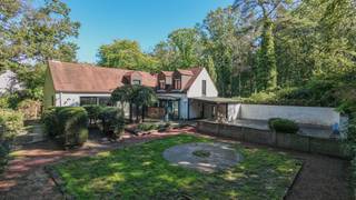 <p>Op een bijzonder gegeerde locatie, pal aan de toegang tot het Zoerselbos, bevindt zich deze charmante villa met vier slaapkamers, twee badkamers en een uitzonderlijk potentieel. Een unieke woonomgeving waar rust, groen en privacy centraal staan, terwijl een vlotte bereikbaarheid behouden blijft. De woning is gelegen in een residentiële en uitgesproken groene omgeving, omgeven door prachtige natuur en met tal van wandel- en fietsroutes letterlijk voor de deur. Een ideale locatie voor wie dagelijks wil genieten van het buitenleven zonder in te boeten aan bereikbaarheid. De villa vraagt om renovatie, maar vormt dankzij haar ruime volumes, praktische indeling en uitstekende ligging een bijzonder interessante basis om uit te groeien tot een prachtige hedendaagse gezinswoning. Met een slaapkamer en badkamer op het gelijkvloers behoort bovendien gelijkvloers wonen tot de mogelijkheden.</p>
<p><strong>GELIJKVLOERS<br /></strong><strong>Inkomhal 14m²</strong> op tegel met gastentoilet en handenwasser. <strong>Woonkamer 48m²</strong> op parket met palletkachel, houtopslag en ingemaakte kasten.<br />Aansluitend bevindt zich <strong>de veranda van 22m²</strong> op natuursteen. <br /><strong>Keuken 12m²</strong> uitgerust met inductiekookplaat, ingebouwde koelkast met diepvriezer, stoomoven, combioven, dampkap, composieten werkblad en dubbele spoelbak.<br /><strong>Hoofdslaapkamer 24m²</strong> op laminaat met aansluitend de <strong>hoofdbadkamer 9m²</strong> met ligbad, douche, dubbel lavabomeubel, spiegelkasten en ingemaakte kasten.</p>
<p><strong>Garage 33m</strong>² op beton met automatische toegangspoort en uitgietbak.</p>
<p>De woning beschikt over een fraai aangelegde tuin met te renoveren zwembad. Het overdekte terras van 9m² is voorzien van een sauna en technische ruimte voor het zwembad.</p>
<p><strong>1STE VERDIEPING<br /></strong>De o<strong>verloop 12m²</strong> geeft toegang tot <strong>3 slaapkamers </strong>van elks<strong> ca. 17m², </strong>een <strong>2de badkamer </strong>van<strong> 6m²</strong> met dubbele lavabo, spiegelkasten, zitbad en toilet, alsook tot<strong> </strong>een <strong>opbergzolder.</strong></p>
<p><strong>BIJZONDERHEDEN<br /></strong>Volledig omheinde tuin, dubbele beglazing en houten schrijnwerk.</p>
<p><strong>POSITIEVE PUNTEN<br /></strong>100% Privacy<br />Zéér goede bereikbaarheid<br />Groene, bosrijke omgeving<br />Gelijkvloers wonen mogelijk<br />Gelegen aan de ingang van Zoerselbos</p>