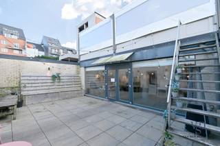 Commercieel pand, bestaande uit een gelijkvloers niveau (met terras), een praktische kelderverdieping én drie garages.<br />De residentie wordt vervolledigd met twee appartementen (één op de eerste en één op de tweede verdieping), welke desgewenst mee aangekocht kunnen worden. Ideaal voor een investeerder.<br />Vrij bij akte (eveneens vrij van brouwer).<br /><br />De onderste verdieping beschikt over een zaal van meer dan 65 m², keuken en berging, en tot slot de sanitaire cellen.<br />De handelszaak (het gelijkvloers) beschikt over meer dan 130 m² (naast het terras, binnenkoer, ...).