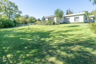 Century21 ImmoNero presenteert deze prachtig gerenoveerde bungalow van 221m² met uitzonderlijke afwerking, in een schitterende parktuin van 3.771m² welke u absolute rust en privacy waarborgt. Via de elektrische toegangspoort komt u het domein binnen langs de brede, verlichte privé oprit met een 6 tal parkeerplaatsen. De bungalow welke zeer grondig en volledig werd vernieuwd in 2020 -2025 biedt vervolgens: Inkom met WC, schitterende living van 78m² met hypergeïnstalleerde keuken , welke naadloos doorloopt in de prachtig aangelegde terrassen, deels overdekt, met subliem zicht op de parktuin; Ingerichte wasplaats 7m² en 2 kinderkamers van elk 12m² met ingemaakte kasten en Douche kamer; Master bedroom bestaande uit een ingerichte dressing, kamer 26m² en een en suite badkamer. Grote garage van 21m², Carport voor 2 wagens en tuinberging. Verwarming met warmtepomp, zonnepanelen en Airco in alle ruimtes. Alu ramen, ventilatie D, Laadpaal, Camerabewaking rondom, Elektriciteit is conform. EPC = B. meer info: www.sintannastraat81.be