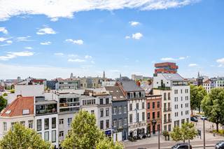 Op de 5e verdieping van een kwalitatief residentieel gebouw aan de Londenstraat 3 bevindt zich dit stijlvolle en ruime appartement van ca. 116 m².<br /><br />Dankzij de combinatie van een hoogwaardige afwerking, hedendaags comfort en een royaal inpandig terras van ca. 12 m² met zicht op het MAS, biedt dit appartement een aangename woonervaring op een toplocatie.<br /><br />De ruime leefruimte vormt samen met de open keuken het hart van het appartement. De keuken is volledig uitgerust met kwalitatieve AEG-toestellen en sluit mooi aan bij de lichtrijke woon- en eetruimte. Vanuit de leefruimte is er toegang tot het ruime inpandige terras, dat een aangename buitenruimte vormt.<br /><br />Het appartement beschikt over twee volwaardige slaapkamers en twee badkamers, wat zorgt voor optimaal wooncomfort en privacy. De ingemaakte kasten van het Italiaanse kwaliteitsmerk Caccaro bieden bovendien een stijlvolle en praktische oplossing voor voldoende opbergruimte.<br /><br />Op het vlak van comfort is het appartement voorzien van vloerverwarming, airconditioning en zonnewering. Het appartement is daarnaast uitgerust met zonnepanelen, wat bijdraagt aan een lager energieverbruik en een aanzienlijke besparing op de energiekosten.<br /><br />Verder beschikt het appartement over een grote ondergrondse autostaanplaats en maar liefst drie overdekte fietsenplaatsen.<br /><br />Huurprijs: € 1950/maand<br />Ondergrondse autostaanplaats: € 150/maand<br />Algemene kosten: € 150/maand<br /><br />Een uitstekend gelegen en hoogwaardig afgewerkt appartement voor wie op zoek is naar ruimte, comfort en een stijlvolle woonomgeving in het Eilandje.<br /><br />Meer informatie of een bezichtiging? Mail naar info@wellimmo.net of bel 03 225 00 68.