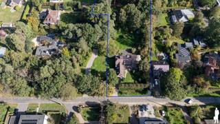 <strong>Royale villa op uitzonderlijk groen domein van ca. 4.708 m² nabij het Zoerselbos + mogelijkheid tot aankoop van naastgelegen perceel van ca. 1.520 m²</strong><br /><br /><strong>Op een prachtig groen en volledig afgesloten perceel van ca. 4.708 m², vlak bij het Zoerselbos, bevindt zich deze bijzonder ruime en uitstekend onderhouden villa. De woning werd in 2000 grondig gerenoveerd en uitgebreid en combineert royale leefruimtes met een sterke connectie met de tuin. Grote glaspartijen, veel privacy en een veelzijdige indeling zorgen voor een bijzonder aangename woonbeleving.</strong><br /><br /><strong>Gelijkvloerse verdieping</strong><br />
<ul>
<li>Ruime inkomhal met karaktervolle boogvormen, natuurstenen vloer, gastentoilet met handenwasser en afzonderlijke verstiaire;</li>
<li>Prachtige leefruimte op natuursteen met grote glaspartijen, dubbele schuiframen en een voormalige zitput, heden dichtgemaakt en geïntegreerd in de leefruimte, met een bijzonder mooi zicht op het terras en de tuin;</li>
<li>Royale leefkeuken in een vooruitgeschoven volume, waardoor het groen rondom volop beleefd wordt, met dubbele spoelbak en toestellen waaronder een AGA-fornuis, Smeg ingebouwde friteuse, Miele vaatwasser, Siemens oven en microgolfoven en een Liebherr koelkast en diepvriezer;</li>
<li>Praktische bijkeuken met ingemaakte kasten, spoelbak en toegang tot terras en tuin;</li>
<li>Twee ruime kamers op parket, ideaal als slaapkamer, bureau, speelkamer of afzonderlijke tv-kamer;</li>
<li>Inpandige garage met automatische poort;</li>
</ul>
<strong>Eerste verdieping</strong><br />
<ul>
<li>Nachthal met afzonderlijk toilet en handenwasser;</li>
<li>Hoofdslaapkamer op parket met toegang tot het dakterras en prachtig zicht over de tuin;</li>
<li>Badkamer met ligbad met jacuzzifunctie, douche, dubbele wastafel en bidet;</li>
<li>Drie bijkomende slaapkamers op parket;</li>
<li>Praktische opbergruimte onder de schuine dakvlakken;</li>
</ul>
<strong>Kelder</strong><br />
<ul>
<li>Kelderruimte met ingemaakte kasten met geïntegreerde koel- en diepvriesvoorzieningen;</li>
<li>Bijkomende bergmogelijkheden;</li>
</ul>
<strong>Tuin en buitenruimte</strong><br />
<ul>
<li>Uitzonderlijk ruime en prachtig aangelegde tuin met volwassen bomenbestand;</li>
<li>Uitgestrekte gazonzones, sierbomen, hagen en sfeervolle vijver;</li>
<li>Ruim terras en gedeeltelijk overdekt terras aansluitend op de leefruimtes;</li>
<li>Diepe zichtlijnen en een bijzonder gevoel van rust en privacy;</li>
<li>Chalet/gastenverblijf met badkamer, toilet, kitchenette en afzonderlijke recente verwarmingsketel;</li>
<li>Serre en tuinhuis met bijkomende opbergruimte en 3 carports;</li>
<li>Volledig omheind en afgesloten domein met automatische toegangspoort;</li>
<li>Robotmaaier</li>
</ul>
<strong>Algemeen</strong><br />
<ul>
<li>Woning grondig gerenoveerd en uitgebreid in 2000;</li>
<li>Elektrische installatie vernieuwd in 2004 (en conform);</li>
<li>Verwarming op aardgas (deels) via vloerverwarming;</li>
<li>Wateronthardingsinstallatie JUDO;</li>
<li>Parketvloeren recent opnieuw opgeschuurd;</li>
<li>Interieur en buitenschrijnwerk recent volledig opnieuw geschilderd;</li>
<li>Zeer verzorgde en uitstekend onderhouden eigendom;</li>
<li>Videofonie;</li>
<li>Veelzijdige indeling met mogelijkheden voor thuiswerk, hobby, gasten of bijkomende slaapkamers;</li>
<li>Bijzonder veel privacy dankzij de omvang en groene omkadering van het perceel;</li>
</ul>
<strong>Optioneel naastgelegen perceel</strong><br />Naast het hoofdeigendom bevindt zich een afzonderlijk perceel van ca. 1.520 m², optioneel aan te kopen aan € 398.000. Op dit perceel bevindt zich momenteel een achterliggend atelier met een carport.