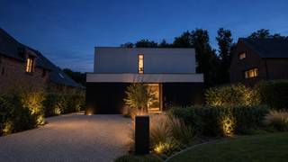 Deze moderne concrete house combineert hedendaags wooncomfort met een luxueuze afwerking op toplocatie. De woning is gelegen in een rustige, residentiële en vóóral een kindvriendelijke omgeving. De geothermische warmtepomp, hoogwaardige beglazing en 27 zonnepanelen zorgen voor een EPC-label “A” met een score van “8 kwh”. Dankzij de slaapkamer en aansluitingen voor een badkamer op het gelijkvloers, is gelijkvloers wonen perfect mogelijk.<br /><br /><strong>GELIJKVLOERS</strong><br />De ruime <strong>inkomhal van 15m²</strong> op polybeton beschikt over een gastentoilet en handenwasser.<br />Het <strong>bureel/slaapkamer van 12m²</strong> op polybeton biedt de mogelijkheid tot een aparte ingang en aansluiting voor een badkamer. Hierdoor is deze ruimte ideaal als bureel, slaapkamer of praktijkruimte.<br />De<strong> woonkamer van 30m²</strong> op polybeton beschikt over een bio-ethanolhaard. <br />Aansluitend bevindt zich de strakke <strong>leef-eetkeuken van 32m²</strong>, eveneens op polybeton, voorzien van een AEG-kookplaat, koelkast, diepvriezer, vaatwasser, stoomoven, combi-oven, warmhoudlade en spoelbak. Het kookeiland, de ontbijthoek en het werkblad in kwartsiet Solntorano zorgen voor een luxueuze uitstraling. Ook hier kan u genieten van de bio-ethanolhaard.<br /><br /><strong>De garage van 22m²</strong> op beton beschikt over een sectionale poort en auto/goederen lift.<br /><br />Vanuit de leefruimtes is er toegang tot het <strong>terras van 30m²</strong> op polybeton en het <strong>overdekte terras van 10m²</strong>. <br />De aangelegde tuin beschikt over tuinverlichting en een beregeningssysteem.<br /><br /><strong>KELDER 101M²</strong><br />De ondergrondse verdieping is een ware droom voor autoliefhebbers of kan dienstdoen als opslagruimte of magazijn.<br />De kelder beschikt tevens over een <strong>wasplaats van 9m²</strong> met waskoker en aansluitingen voor wasmachine en droogkast, alsook van een technische ruimte van 10m².<br /><br /><strong>1STE VERDIEPING</strong><br />De ruime <strong>overloop van 25m²</strong> op parket beschikt over een nachttoilet, linnenkasten en dressingkasten.<br />De <strong>hoofdslaapkamer van 15m² </strong>op parket sluit aan op de <strong>dressing van 10m²</strong> en de <strong>hoofdbadkamer van 12m²</strong> op tegel, voorzien van ligbad, inloopdouche en dubbel lavabomeubel.<br />Verder zijn er nog 2 <strong>slaapkamers </strong>van telkens <strong>15m²</strong> op parket. <br />De<strong> 2de badkamer van 6m²</strong> op tegel beschikt over een inloopdouche en enkele lavabo.<br /><br /><strong>BIJZONDERHEDEN</strong><br />Geothermische warmtepomp voor verwarming en koeling, vloerverwarming doorheen de hele woning, 27 zonnepanelen (12.000 kwh/jaar), laadpaal (22 kwh), domoticasysteem van Nico Home Control, driedubbele beglazing inbraakwerend, geluidsisolerend en zonwerend, pakjesbrievenbus, blokdeuren, geboord put, regenwaterput van 10.000 liter, beregeningsysteem, vaste vliegenhorren, dimmers en ingebouwde spots.<br /><br /><strong>POSITIEVE PUNTEN</strong><br />EPC-label A<br />Zonnige tuin<br />Auto/goederenlift<br />Rolstoeltoegankelijk<br />Co-housing mogelijk<br />Kindvriendelijke omgeving<br />Ideaal voor wonen/werken<br />Gelijkvloers wonen mogelijk<br />Rustige residentiële omgeving<br />Hedendaagse, luxueuze afwerking<br />Volledig aangelegde en omheinde tuin