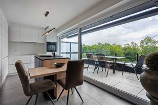 Op een uitstekende locatie, vlak bij het centrum van Heist-op-den-Berg, bevindt zich dit lichtrijke duplexappartement met drie slaapkamers, twee terrassen en een garagebox. Het appartement ligt op wandelafstand van het centrum, waar winkels, scholen en openbaar vervoer vlot bereikbaar zijn.<br /><br />Interesse in dit prachtige appartement? Klik hier voor een persoonlijke digitale rondleiding!<br /><br />Via de inkomhal op de derde verdieping, betreden we het appartement. De ruime en lichtrijke leefruimte biedt volop mogelijkheden. Aansluitend aan de zithoek bevindt zich het eerste terras van 7 m², met noordwestelijke oriëntatie. Er is bovendien ruimte voor een extra gezellig zithoekje. De sfeervolle eetruimte grenst aan de volledig uitgeruste keuken die afgewerkt is met kwalitatieve toestellen en geeft toegang tot het tweede terras van 11 m², met zuidoostelijke oriëntatie. Naast de keuken bevindt zich bovendien een praktische berging. Op deze verdieping is ook een apart gastentoilet voorzien.<br />Via de nachthal op de vierde verdieping bereiken we drie slaapkamers, een apart toilet en een badkamer met ligbad, inloopdouche en wastafel. Al de slaapkamers zijn, net als de leefruimte, uitgerust met airco. De garagebox is mee aan te kopen voor €35.000 en is voorzien van een laadpaal.<br /><br />Dit duplexappartement is uitgerust met airco's in alle kamers, kwalitatieve insectenhorren, zonnepanelen, een batterij en een ventilatiesysteem, wat resulteert in een uitstekende energiescore (EPC A - E-peil E15). Zo is het er, op een energiezuinige manier, lekker warm in de winter en heerlijk koel in de zomer.<br /><br />Dit is een uitstekende opportuniteit als u op zoek bent naar een lichtrijk appartement met drie slaapkamers, twee terrassen en een garagebox te Heist-op-den-Berg. Contacteer ons voor meer informatie op 0479 13 63 69 of via info@boonstravastgoed.be.<br /><br />Bijzonderheden:<br />- Garagebox<br />- 3 slaapkamers<br />- Twee terrassen