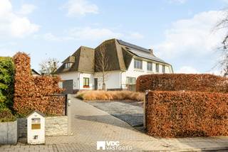 Op een uitzonderlijk perceel van 1.799 m² met prachtig uitzicht op de bloesemweide bevindt zich deze ruime villa met geïntegreerde praktijkruimte. Dankzij de aparte inkom, wachtzaal en ruime parkeergelegenheid is deze eigendom ideaal voor een vrij beroep, maar de praktijkruimte kan ook perfect worden ingericht als extra woonruimte, bureau of hobbyruimte.<br /><br />De woning beschikt over een lichtrijke leefruimte, meerdere ruime slaapkamers met eigen lavabo, een dressing, een zolder over de volledige woning en een gedeeltelijke kelder. De zonnige tuin met jacuzzi biedt alle rust en privacy.<br /><br />Qua comfort is de woning uitgerust met zonnepanelen met groenestroomcertificaten, een thuisbatterij, een warmtepomp met aircofunctie, alarmsysteem en camerabewaking. De elektrische installatie wordt bovendien conform gemaakt.<br /><br />Troeven:<br /><br />Perceel van 1.799 m²<br />Praktijkruimte met aparte inkom en wachtzaal<br />Ideaal voor wonen en werken<br />Ruime parkeergelegenheid<br />Zolder over de volledige woning<br />Gedeeltelijk onderkelderd<br />Zonnepanelen, thuisbatterij en warmtepomp<br />Jacuzzi<br />Elektriciteit conform<br /><br />Een veelzijdige eigendom met tal van mogelijkheden, gelegen op een rustige locatie met een uniek uitzicht.