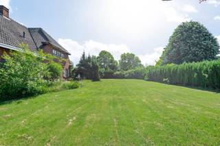 In een doodlopende en bijzonder rustige villawijk, bevindt zich deze riante hoeve op een prachtig perceel van ca. 2.950 m². De ligging is ideaal voor wie rust en ruimte zoekt, maar toch vlot bereikbaar wil wonen: op korte afstand van het centrum van Schilde en Oelegem, het Albertkanaal en de oprit van de E34. Een uitzonderlijke locatie met veel groen, privacy en mogelijkheden.<br /><br />Met een straatbreedte van meer dan 80 meter biedt dit perceel, mits afbraak van het bijgebouw en/of de hoeve, interessante verkavelingsmogelijkheden. Het grote bijgebouw, voorheen deels in gebruik als stallen en nu als opslag, vormt bovendien een enorme troef voor wie nood heeft aan extra ruimte voor een praktijk, kantoor, atelier, zorgwonen of stockage. Ook de inpandige garage met grote zolderruimte biedt verrassend veel potentieel.<br /><br />Via de inkomhal met vestiaire en gastentoilet betreedt men de woning. De ruime woonkamer met authentieke open haard sluit naadloos aan op de eetkamer. De leefkeuken heeft onmiddellijk toegang tot de voorraadkelder en de traphal, en grenst aan een tussenruimte die dienst kan doen als bureau of bijkeuken. Vanuit deze ruimte is er toegang tot de indrukwekkende inpandige garage van ca. 75 m², waar zich een wasplaats met toilet en douche bevindt. Een trap leidt ernaar een ruime zolder, ideaal voor het creëren van extra kamers of een hobbyruimte.<br />Op de eerste verdieping biedt een centrale overloop toegang tot vier ruime slaapkamers en een badkamer ingericht met ligbad, dubbele wastafel, bidet en toilet. De woning beschikt bovendien over een praktische kelder.<br /><br />De tuin strekt zich rondom de gebouwen uit en omvat een royale oprit, een zonnige tuin en een achterliggende speelweide. Dankzij de enorme breedte en oppervlakte van het perceel zijn hier diverse toekomstige mogelijkheden denkbaar, zowel voor particulier gebruik als voor ontwikkeling.<br /><br />De bewoonbare oppervlakte bedraagt 221 m², exclusief zolder en garage. Wanneer deze ruimtes worden meegerekend, biedt de woning meer dan 400 m² aan bruikbare oppervlakte.<br /><br /><strong>Bijzonderheden</strong><br /><strong>+ Uitzonderlijk perceel van ca. 2.950 m²</strong><br /><strong>+ Straatbreedte van meer dan 80 meter met verkavelingspotentieel</strong><br /><strong>+ Inpandige garage van ca. 75 m² met zolderruimte</strong><br /><strong>+ Groot vrijstaand bijgebouw met tal van mogelijkheden</strong><br /><strong>+ Rustige ligging in een doodlopende villawijk nabij E34 en centrum</strong>