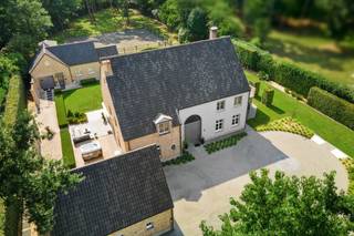<p><span> </span></p><p><span>Cette villa majestueuse bénéficie d'un emplacement exceptionnel sur un terrain d'environ 5 000 m², jouxtant directement le golfe de Rinkven. </span></p><p><span>La propriété comprend une maison de campagne très spacieuse aux finitions luxueuses, une dépendance multifonctionnelle dotée d’un logement indépendant, une piscine à débordement chauffée et des installations équestres. La villa a été construite en 1999 et entièrement rénovée en 2020. Lors de cette rénovation, une attention particulière a été portée au confort de vie contemporain ; des matériaux haut de gamme ont été utilisés, avec des finitions particulièrement soignées. La combinaison d’un cadre verdoyant, à proximité immédiate du parcours de golf, et d’installations complètes pour l’élevage d’animaux fait de cette propriété un bien exceptionnel situé dans un cadre unique.</span></p><p><span> </span></p><p><span>Agencement</span><span>: vous entrez dans la villa par le vaste hall d’entrée doté d’un vestiaire, de toilettes pour invités et d’un escalier menant à l’étage. Depuis le hall d’entrée, vous accédez également à un bureau indépendant, idéal pour travailler au calme à domicile. Les vastes espaces de vie se composent d’une grande salle à manger, d’un salon convivial doté d’une cheminée à gaz à double face et d’un salon séparé. De grandes baies vitrées laissent entrer beaucoup de lumière naturelle et offrent une belle ouverture sur le jardin et la verdure environnante. Au cœur de l’espace de vie se trouve la luxueuse cuisine sur mesure. Celle-ci est équipée d’une gamme complète d’appareils encastrés haut de gamme, d’un îlot de cuisine spacieux et de plaques de cuisson intégrées de manière quasi invisible. À proximité se trouvent une buanderie pratique et un débarras frais. Depuis la maison, vous avez accès au double garage intégré. L’étage au-dessus du garage a été aménagé en un vaste espace de détente polyvalent et sert actuellement de salle de jeux et de fitness.</span></p><p><span> </span></p><p><span>Étage</span><span>: À l'étage, vous accédez au couloir central donnant accès à trois chambres spacieuses, dont l'une est actuellement aménagée en dressing. Ces chambres disposent d'une salle de bains séparée avec douche à l'italienne et meuble-lavabo sur mesure. La spacieuse suite</span><span>parentale</span><span> </span><span>comprend une grande chambre, un dressing privatif et une salle de bains luxueusement aménagée avec baignoire et grande douche à l'italienne.</span></p><p><span> </span></p><p><span>Grenier</span><span>: Un escalier fixe donne accès au vaste grenier. Celui-ci abrite actuellement les installations techniques et un débarras. La surface disponible offre en outre la possibilité d’aménager des chambres et salles de bains supplémentaires ou d’autres espaces polyvalents.</span></p><p><span> </span></p><p><span>Annexe multifonctionnelle</span><span>: Outre la maison principale, la propriété dispose d'une annexe à part entière, actuellement aménagée en salon de beauté et équipée d'installations d'habitation indépendantes. Le rez-de-chaussée comprend un hall d’entrée, un débarras ou un garage, une salle de bains avec douche à l’italienne, des toilettes et un meuble-lavabo, ainsi qu’un espace de vie avec une cuisine entièrement équipée comprenant un lave-vaisselle, un four et un four à micro-ondes «  ». Le débarras peut également servir de chambre au rez-de-chaussée si vous le souhaitez. À l’étage se trouvent deux chambres spacieuses et un débarras supplémentaire. Grâce à son agencement et à ses équipements indépendants, ce bâtiment se prête parfaitement à une utilisation en tant que maison d’hôtes, cabinet professionnel, bureau ou logement pour le personnel résidant sur place.</span></p><p><span> </span></p><p><span>Jardin et espaces extérieurs</span><span>: La villa est entourée d’un vaste jardin aménagé offrant beaucoup de calme et d’intimité. Depuis les pièces à vivre, vous profitez d’une vue magnifique sur le domaine privé et le parcours de golf de Rinkven adjacent. La piscine à débordement chauffée constitue un véritable point de mire dans le jardin. Conçue comme une piscine à débordement, elle dispose également d’une douche extérieure. De spacieuses terrasses ont été aménagées tout autour de la piscine.</span></p><p><span> </span></p><p><span>Équipements équestres</span><span>: pour les amateurs de chevaux, la propriété dispose de ses propres écuries, d'un pré et d'un paddock. Les environs offrent par ailleurs de magnifiques possibilités de randonnées à pied et à cheval. </span></p><p><span> </span></p><p><span>Particularités</span><span>: La villa est notamment équipée d’un chauffage au sol, de la climatisation, d’un système domotique, ainsi que d’un système d’alarme complet et d’une vidéosurveillance. Des panneaux solaires et des capteurs solaires contribuent au caractère économe en énergie de la propriété. La propriété bénéficie d’un label EPC B, très favorable. La combinaison d’une villa luxueusement rénovée, d’une annexe multifonctionnelle, d’installations équestres et d’une piscine chauffée sur un terrain d’environ 5 000 m² en fait un domaine particulièrement complet, situé dans un cadre magnifique à proximité du golf de Rinkven.</span></p><p><span> </span></p><p><span>Pour plus d’informations, veuillez contacter notre agence.</span></p>