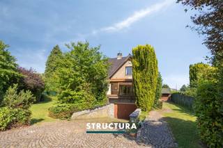 Bent u op zoek naar een ruime gezinswoning die u volledig naar eigen smaak kunt renoveren? Dan is deze vrijstaande villa precies wat u zoekt. Gelegen in een rustige doodlopende straat geniet u hier van alle privacy en een veilige woonomgeving, terwijl u dankzij de vlotte verbinding met de Ring en de A12 toch snel uw bestemming bereikt. Met een perceel van 8a01ca, een bewoonbare oppervlakte van ca. 240 m², vier volwaardige slaapkamers, een grote garage en tal van bergruimtes biedt deze woning een uitstekende basis voor wie ruimte en potentieel weet te waarderen.IndelingGelijkvloers: ruime inkomhal met gastentoilet, lichtrijke leefruimte met gezellige houthaard, aparte keuken, veranda en bureau.Eerste verdieping: nachthal, vier ruime slaapkamers van ca. 18,2 m², 18,7 m², 19,6 m² en 20,54 m² en een badkamer uitgerust met zowel een ligbad als een douche.Zolder: praktische zolderruimte bereikbaar via een valtrap, ideaal als extra bergruimte.Kelder: ruime garage en verschillende kelderruimtes die zorgen voor extra opslagmogelijkheden/werkruimte of ateliermogelijkheden. Buiten: ruime oprit met plaats voor meerdere wagens en een aangenaam perceel van 8a01ca.Karakteristieken- Vrijstaande villa- Rustig gelegen in een doodlopende straat- Bureau op het gelijkvloers- Te renoveren en volledig naar eigen smaak in te richten- Vrij bij akte- Maatregelen in het maatregelenregister: neeDankzij de ruime volumes, de uitstekende ligging en de vele mogelijkheden vormt deze villa de ideale opportuniteit voor gezinnen die op zoek zijn naar een woning met karakter en renovatiepotentieel. Wenst u deze eigendom te ontdekken? Contacteer ons vandaag nog voor meer informatie of plan uw bezoek in via 02 460 80 46 of info@structura.be