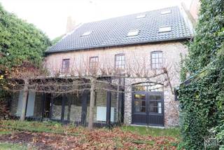 Deze charmante stadsboerderij, genaamd "Die Witte Roose", waarvan de voorgevel als monument is geklasseerd, stamt uit de 17de eeuw. Door het behoud van authentieke materialen is de rustieke uitstraling van dit pand bewaard gebleven. De aangename ligging in het centrum van Maaseik, in een verkeersvrije straat is een pluspunt. Scholen, openbaar vervoer, winkels, restaurants, sportcentra, ... zijn op wandelafstand bereikbaar. De gerenoveerde stadsboerderij dient zijn bestemming te behouden en het oude poortgebouw van deze boerderij moet een officiële doorgang bieden tot het te ontwikkelen binnengebied. <br /><br />=> Gelijkvloers <br />-Via de sas met glazen deur, komt u binnen in de royale inkomhal<br />- Hier ervaart u direct de warme sfeer die deze stadsboerderij uitstraalt<br />- Directe toegang tot zowel de keuken als de woonkamer<br />- Gezellige, ruime woonkamer met kalkstenen open haard en rode gebakken tegelvloer<br />- Tussen de inkomhal en de keuken is er een mooie dubbele houten deur<br />- De nieuwe, witte aanbouwkeuken is voorzien van o.a. een elektrisch fornuis, een combi-oven, een vaatwasser, een koelkast met diepvrieszak,...<br />- Aan de achterzijde is er een zonnige tuinkamer/veranda met schuifraam <br />- Hier kan u heerlijk vertoeven met een prachtig zicht op de tuin<br />- De gewelfde mergelkelder is toegankelijk via een valluik vanuit de woonkamer<br /><br />=> Verdieping <br />- Via de mooie houten trap bereikt u de verdieping <br />- Overloop met toegang tot de slaapkamers<br />- Drie slaapkamers met houten plankenvloer<br />- Badkamer met ligbad, toilet en dubbele wastafel in inbouwmeubel<br />- Op de overloop kan er een bureel-/hobbyruimte of extra (vierde) slaapkamer gecreëerd worden, die open is tot aan de nok. Via het luik in de nachthal gaat u naar de ruime zolder, dewelke u naar eigen keuze kan inrichten.<br /><br />=> Tuin<br />- Volledig ingesloten stadstuin aan de achterzijde van de hoeve <br />- Tuinberging en ruimte voor houtopslag<br />- U kan genieten genieten in volledige rust en privacy van uw eigen tuin in het midden van de stad<br /><br />=> Indeling<br />- Gelijkvloers: inkomhal met vestiaire, apart toilet, woonkamer, keuken en veranda/tuinkamer <br />- Eerste verdieping: overloop voor hobbyruimte/bureel/extra slaapkamer, drie slaapkamers , badkamer<br />- Zolder en kelder