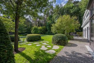 <p><span>Deze karaktervolle Vlassak-Verhulst-villa biedt een uitzonderlijke verbinding tussen architectuur, wooncomfort en natuur. De woning is prachtig gelegen in de gemeente Zoersel, op de grens met Schilde, en grenst rechtstreeks aan het indrukwekkende Driehoeksbos. De aangelegde tuin vormt hierdoor een natuurlijk verlengstuk van de leefruimtes.</span></p>
<p><span>Binnen geniet u van royale en lichtrijke leefruimtes, waarbij de open woonkamer en eetruimte via grote raampartijen rechtstreeks in verbinding staan met de tuin en terrassen. De keuken met aangrenzende tuinkamer is ideaal voor wie graag binnen en buiten laat samenvloeien.</span></p>
<p><span>Een absolute troef is de uitgebreide poolzone met zwembad op basis van zoutelektrolyse. Het ruime poolhouse beschikt over een volledig uitgeruste buitenkeuken met Braai Master, Big Green Egg, vaatwasser en koelkast. Daarnaast zijn er een sauna, buitendouche, irrigatiesysteem en grondwaterput. Een ruime fietsenberging biedt bijkomende praktische bergruimte en herbergt tevens de zwembadinstallatie.</span></p>
<p><span>Op de eerste verdieping bevinden zich vier slaapkamers. De master bedroom beschikt over een dressing en ensuite badkamer. Daarnaast zijn er nog twee bijkomende badkamers en een zolderruimte.</span></p>
<p><span>Ook op het gelijkvloers werd aandacht besteed aan comfort en functionaliteit, met een ruime inkomhal met gastentoilet en vestiaire, een praktische berging met maatkasten (voormalige garage) en een kelder.</span></p>
<p><span>De woning is uitstekend onderhouden en afgewerkt met hoogwaardige materialen zoals parket, natuursteen en maatwerkinterieurs. Het comfort wordt verder aangevuld met airconditioning, een alarmsysteem en centrale verwarming. De woning beschikt over een gunstig EPC-label B.</span></p>
<p><span>Buiten geniet u van een prachtig aangelegde, zuidgerichte tuin met volwassen groen, verschillende terrassen, optimale privacy en meerdere autostaanplaatsen.</span></p>
<p><span>Een unieke eigendom voor wie op zoek is naar ruimte, rust, privacy en een hoogwaardige woonomgeving, met het Driehoeksbos letterlijk als achtertuin.</span></p>
<p><span>Ontdek deze bijzondere villa tijdens een persoonlijke bezichtiging.</span></p>