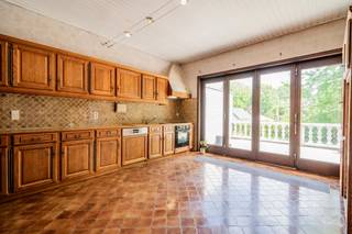 Située dans le village de Marilles, entre Jodoigne et Hannut, cette spacieuse maison construite en 1980 offre de beaux volumes et un cadre de vie agréable sur un terrain de plus de 10 ares.<br /><br />Le rez-de-chaussée se compose d'un lumineux séjour, d'une cuisine, de trois chambres de 11 m², 14 m² et 16 m², ainsi que d'une salle d'eau. Une belle terrasse surélevée prolonge les espaces de vie et offre une vue dégagée sur le jardin.<br /><br />À l'étage, vous découvrirez deux grandes chambres de 21 m² et 24 m² ainsi qu'une salle de bains, offrant un espace idéal pour une famille nombreuse ou pour l'aménagement d'un bureau et d'une chambre d'amis.<br /><br />La maison bénéficie également de caves sous toute sa superficie, avec un accès garage particulièrement pratique pour le stationnement, le rangement ou un atelier.<br /><br />Côté technique, le bien est équipé de 26 panneaux photovoltaïques et d'une chaudière datant d'environ 20 ans. Le certificat PEB affiche la classe énergétique C avec une consommation spécifique de 251 kWh/m².an (PEB n° 20260609050769).<br /><br />Le bien nécessite un rafraîchissement général, offrant ainsi aux futurs propriétaires l'opportunité de le remettre au goût du jour et de l'aménager selon leurs envies tout en profitant de ses beaux volumes et de sa configuration familiale.<br /><br />Une maison lumineuse de 5 chambres, avec jardin et nombreuses possibilités d'aménagement, à découvrir sans tarder !<br /><br />PEB : C – 251 kWh/m².an – Code unique : 20260609050769.
