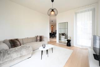 Dit ruime en kwalitatief afgewerkte appartement van 99 m² met een terras van 15 m² maakt deel uit van het recente nieuwbouwproject Liv De Molens. Het appartement omvat twee slaapkamers en een lichtrijke leefruimte met open keuken. De grote raampartijen zorgen voor een overvloed aan natuurlijk licht en bieden een rechtstreeks zicht op de Leie. Het westelijk georiënteerd terras heeft een oppervlakte van 15 m². De afwerking is van hoog niveau, met onder meer vloerverwarming, parketvloeren en duurzame materialen die bijdragen aan een aangenaam en energie-efficiënt wooncomfort. Dankzij de doordachte indeling is dit appartement geschikt voor zowel eigen bewoning als investering. Naast de ondergrondse berging die is inbegrepen in de prijs, kan er ook een ondergrondse staanplaats worden aangekocht aan de prijs van 35.000 euro. Het appartement is momenteel verhuurd aan €950 per maand, exclusief €80 provisie, wat het tot een interessante investeringsopportuniteit maakt met onmiddellijk rendement. Indien de koper het pand zelf wenst te betrekken, dient rekening te worden gehouden met de wettelijke opzegtermijnen. De verkoop vindt plaats onder het tarief van 2% registratierechten bij aankoop als enige en eigen woning, of 12% voor investeringsdoeleinden. Epeil 22 / centrale verwarming op aardgas 