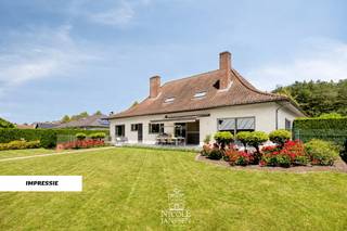 Verscholen in een groene en rustige omgeving bevindt zich deze riante villa. De woning werd degelijk gebouwd en altijd met zorg onderhouden. Doorheen de jaren werd ze smaakvol gerenoveerd met respect voor haar authentieke charme. Het overdekt zwembad, de sauna en het uitgestrekte domein zorgen voor een uitzonderlijke woonbeleving. <br />Een extra troef is dat de woning beschikt over een gunstig EPC-label en een conforme elektrische installatie.<br /><br />=> Ligging<br />De woning is gelegen te midden van de natuur, in een groene en rustige omgeving. Dankzij de vele fiets -en wandelmogelijkheden in de buurt, is dit de ideale locatie voor natuurliefhebbers. Een echte oase van rust, terwijl winkels, scholen en andere voorzieningen vlot bereikbaar blijven. <br /><br />=> Gelijkvloers<br />- Royale inkomhal met keramische tegelvloer en een stijlvolle eiken trap naar de verdieping<br />- Er is ook vestiaireruimte voorzien en een apart gastentoilet met lavabo<br />- Ruime leefruimte met gezellige zithoek voorzien van houthaard en aparte eetplaats<br />- Grote schuiframen zorgen voor een mooie verbinding met de tuin en veel natuurlijk lichtinval<br />- Het behoud van de authentieke elementen zorgt voor een warm en karaktervolle sfeer<br />- Ruime leefkeuken met granieten werkblad, kwalitatieve toestellen en gezellige eetruimtes<br />- Aansluitende berging met inbouwkasten, aansluiting voor wasmachine en droogkast en apart toilet<br />- Praktische bureauruimte aan de voorzijde van de woning<br />- Master bedroom met prachtig zicht op de tuin<br />- Twee bijkomende slaapkamers, ideaal voor wie het comfort van gelijkvloers wonen wenst<br />- Badkamer uitgerust met ligbad, douche en lavabo in een stijlvol badkamermeubel<br /><br />=> Verdieping<br />- Overloop met toegang tot de verschillende kamers<br />- Op deze verdieping bevinden zich nog twee ruime slaapkamers en twee bergzolders<br /><br />=> Kelder<br />- De kelder is toegankelijk via de woning als langs de buitenzijde<br />- Momenteel ingericht met vijf afzonderlijke ruimtes: een grote multifunctionele ruimte, technische ruimte, extra bergruimtes en een ingerichte fitnessruimte <br /><br />=> Tuin<br />- Ruim terras met elektrisch zonneluifel waar je kan genieten van het prachtige uitzicht op de tuin en het omliggende groen<br />- De zuidwestelijk georiënteerde tuin is prachtig aangelegd en volledig omheind voor optimale privacy<br />- Het overdekt zwembad vormt het middelpunt van de tuin<br />- Deze ruimte is tevens voorzien van vloerverwarming<br />- Deze ontspanningsruimte beschikt over een keukenhoek, douche, toilet, kleedkamer en sauna <br />- Charmante pergola met tuinhuis, momenteel ingericht als gezellige lounge- en zithoek om op elk moment van de dag te genieten<br />- Achter de woning bevindt zich meer dan 1,5 hectare bos en weiland, volledig omheind en bereikbaar via een afzonderlijk doorgangsweg aan de achterzijde<br />- Ideaal voor recreatie, dierenliefhebbers of het houden van kleinvee<br />- Dubbele inpandige garage met elektrische kantelpoorten en ingebouwde kastenwand <br /><br />=> Indeling<br />- Gelijkvloers: inkomhal, gastentoilet, woonkamer met eetplaats, keuken, hal, apart toilet, praktische berging/wasplaats, bureelruimte, master bedroom, twee slaapkamers, badkamer<br />- Verdieping: overloop, twee slaapkamers, twee bergzolders<br />- Zolder: nog af te werken naar eigen wens<br />- Kelder: multifunctionele ruimte, technische ruimte, opbergruimtes, ingerichte fitnessruimte