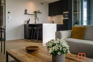 <strong>Move straight into the prestigious Ensor Tower</strong><br />Located on the <strong>10th floor of Ensor Tower in Oosteroever</strong>, Ostend, this stylish <strong>80 m²</strong> apartment, built in <strong>2021</strong>, is ready to move into.<br />Featuring two pleasant terraces, outstanding energy efficiency, and high-quality finishes, it offers modern coastal living in one of Ostend's most desirable locations.<br /><br /><strong>Bright living area with a sunny terrace</strong><br />The welcoming entrance hall with a practical cloakroom leads into a bright and inviting living room with <strong>unique sea views</strong>. Large floor-to-ceiling windows flood the space with natural light while showcasing breathtaking views.<br />The adjoining <strong>10 m²</strong> terrace enjoys the <strong>morning sun until around 2 p.m</strong>., making it the perfect spot for breakfast or a relaxing coffee in the sunshine.<br /><br /><strong>Modern open-plan kitchen</strong><br />The elegant open-plan kitchen blends seamlessly with the living area, creating a spacious and contemporary atmosphere. Its practical layout makes cooking and entertaining especially enjoyable.<br /><br /><strong>Two bedrooms with access to a second terrace</strong><br />The apartment features <strong>2 full-sized bedrooms</strong>, both fitted with <strong>built-in wardrobes</strong> and offering direct access to the generous <strong>8 m²</strong> second terrace.<br />This provides additional outdoor living space and beautiful views from both bedrooms.<br /><br /><strong>High-quality finishes and exceptional comfort</strong><br />Warm <strong>parquet flooring</strong> runs throughout the apartment and complements the comfortable <strong>underfloor heating</strong>, which is connected to the sustainable <strong>district heating network</strong>.<br />The bathroom features a walk-in shower and double washbasin, while a separate storage room and separate toilet add everyday convenience.<br /><br />With an excellent <strong>EPC rating of E43</strong> and an energy consumption of only <strong>66 kWh/m² per year</strong>, this home is exceptionally energy-efficient.<br /><br /><strong>Key features</strong><br /><span><strong>Prime location in Oosteroever</strong>, Ostend</span><br /><span><strong>Ensor Tower</strong> residence (built in <strong>2021</strong>)</span><br /><span>80 m² of living space + 2 terraces measuring 10 m² and 8 m²</span><br /><span>Underfloor heating connected to the district heating network</span><br /><span><strong>EPC E43 – 66 kWh/m²/year</strong></span><br /><span>Cadastral income: € 991</span><br /><span>Option to purchase an underground <strong>garage box</strong> (No. 56) nearby</span><br /><br /><br />Looking for an apartment for sale in Oosteroever, Ostend that combines modern comfort, outstanding energy efficiency, and a prime seaside location?<br />This apartment in Ensor Tower is a unique opportunity.