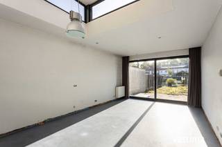 Al een hele poos op zoek naar een betaalbare stadswoning met tuin? Liefst geen oude woning, maar een recenter exemplaar? Dan is deze woning precies wat je zoekt. <br /><br />Deze woning werd gebouwd in 2002 en is ontworpen met het oog op singles, jonge koppels en kleine gezinnen die comfortabel willen wonen zonder de lasten van een grote woning. Compact waar het kan, verrassend ruim waar het moet en het perfecte alternatief voor een appartement! <br /><br />Al bij het binnenkomen merk je dat over de indeling goed is nagedacht. Vooraan beschik je over een handige berg- en fietsenruimte. Geen gedoe meer met fietsen, afval of boodschappen die door de leefruimte moeten. Een klein detail dat elke dag opnieuw een groot verschil maakt. <br /><br />De absolute blikvanger van de woning is zonder twijfel de leefruimte met open keuken. Dankzij de verhoogde dakuitbouw met zijn extra zijramen baadt deze ruimte de hele dag in natuurlijk licht. Het resultaat? Een heerlijk ruimtegevoel dat je van buitenaf nooit zou verwachten. De volledig uitgeruste keuken vormt samen met de leefruimte het hart van de woning. En dankzij de grote raampartij, geniet je bovendien de hele dag door van licht en zicht op je tuin. Verder beschik je op het gelijkvloers over een gastentoilet met handenwasser. <br /><br />Op de eerste verdieping bevinden zich een ruime slaapkamer met aansluitende dressing en een verzorgde badkamer met douche in bad en toilet. Onder het dak vind je nog een tweede slaapkamer en een technische ruimte met extra stockagemogelijkheden. <br /><br />Ook technisch zit je hier helemaal goed. De woning beschikt over een zonneboiler voor warm water in combinatie met een CV op gas, een regenwaterput van 5.000 liter, een conforme elektrische installatie en is volledig asbestvrij. Bovendien geldt er geen renovatieverplichting, waardoor je zonder zorgen kunt verhuizen. <br /><br />Achteraan wacht een gezellige stadstuin met terras waar je na een drukke dag heerlijk tot rust komt.  <br /><br />De woning vraagt hier en daar nog een persoonlijke afwerking, maar net dat biedt je de kans om ze volledig naar jouw smaak af te werken en er écht je eigen thuis van te maken. <br /><br />Ligging is nog een extra troef: rustig, maar toch vlak bij centrum Aalst. Scholen, winkels, openbaar vervoer en grote verbindingswegen bevinden zich op korte afstand. Parkeren doe je vlot op de vele voorbehouden bewonersplaatsen in de straat. <br /><br />Een recente stadswoning met tuin, veel licht, een doordachte indeling en moderne technieken kom je niet elke dag tegen. Benieuwd of dit jouw nieuwe thuis wordt? Contacteer Vastima vandaag nog en plan snel je bezoek! 