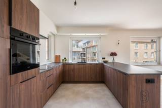 Vous recherchez un appartement élégant aux finitions luxueuses, situé dans un emplacement de premier choix au cœur de Waregem ?Cet appartement rénové avec goût, d'une superficie d'environ 115 m², allie des matériaux haut de gamme, un agencement bien pensé et une architecture intemporelle à une vue magnifique sur l'église. Grâce à ses grandes baies vitrées, vous profiterez toute la journée d'une luminosité exceptionnelle et d'une agréable sensation d'espace.AGENCEMENT : Vous entrez par le hall d’entrée, qui comprend des toilettes pour invités et un vestiaire. Le spacieux salon (parquet) constitue, avec la cuisine design sur mesure, le cœur de l’appartement. La cuisine est équipée d’appareils encastrés haut de gamme et d’un îlot de cuisson et d’évier élégant qui se prolonge naturellement en un bar convivial, idéal pour recevoir des invités. L’appartement dispose en outre de deux chambres, d’une salle de bains et d’espaces de rangement pratiques qui contribuent à un confort de vie optimal.ATTOUS : entièrement rénové avec des matériaux haut de gamme, surface habitable d’environ 115 m², luminosité abondante grâce à de grandes baies vitrées allant du sol au plafond, cuisine exclusive sur mesure avec îlot de cuisson, vue dégagée sur l’église, emplacement de premier choix au centre de Waregem, prêt à emménager et aménagé avec le souci du détail.Un appartement unique où luxe, confort et emplacement de choix s’allient à la perfection.Intéressé(e) ? Contactez-nous à l’adresse charlotte@immobeguin.be