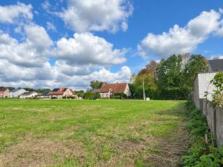 Op een vlot bereikbare locatie tussen het centrum van Berlaar en Itegem bevindt zich deze ruime bouwgrond voor open bebouwing. Winkels, scholen, openbaar vervoer en andere dagelijkse voorzieningen zijn vlot bereikbaar. Tegelijk geniet u hier van een groene omgeving met verschillende wandel- en fietsmogelijkheden in de buurt.<br /><br />Lot 1 maakt deel uit van een goedgekeurde verkaveling voor zes vrijstaande eengezinswoningen. Het perceel heeft een totale oppervlakte van 1.079 m², een straatbreedte van circa 21,50 meter en een diepte van ongeveer 50 meter. Dankzij deze ruime afmetingen zijn er heel wat mogelijkheden voor het bouwen van een volwaardige gezinswoning met een mooie tuin.<br /><br />De woning dient op 8 meter van de rooilijn te worden ingeplant. Aan beide zijden geldt een bouwvrije strook van 4 meter, waardoor een maximale bouwbreedte van circa 13,50 meter mogelijk is.<br /><br /><strong>Bouwmogelijkheden:</strong>
<ul>
<li><span>Gelijkvloerse verdieping: maximaal 13,50 meter breed en 17 meter diep, goed voor circa 229,50 m²</span></li>
<li><span>Eerste verdieping: maximaal 13,50 meter breed en 13 meter diep, goed voor circa 175,50 m²</span></li>
<li><span>Tweede verdieping: maximaal 13,50 meter breed en 9 meter diep, goed voor circa 121,50 m²</span></li>
<li><span>Theoretisch maximaal bruto vloeroppervlak van circa 526,50 m²</span></li>
<li><span>Maximale kroonlijsthoogte van 6 meter</span></li>
<li><span>Maximale nokhoogte van 11 meter</span></li>
<li><span>Keuze tussen een plat dak of een hellend dak met een maximale dakhelling van 45°</span></li>
</ul>
De bouwgrond is bestemd voor een vrijstaande eengezinswoning, eventueel aangevuld met maximaal één zorgwoning. Een beperkte nevenbestemming voor een vrij beroep of dienstverlening is mogelijk, voor zover de woonfunctie behouden blijft. De nevenbestemming mag maximaal 100 m² van de totale vloeroppervlakte innemen.<br /><br />De garage dient inpandig in de woning te worden voorzien. Daarnaast moet er voldoende ruimte aanwezig zijn voor het stallen van fietsen.<br /><br />In de tuinzone mogen bijgebouwen worden opgericht met een gezamenlijke oppervlakte van maximaal 75 m² en een maximale hoogte van 3 meter. De overige verhardingen in de tuinzone worden beperkt tot maximaal 100 m², met uitzondering van de noodzakelijke oprit en het toegangspad naar de woning. De oprit dient aan de rechterzijde van het perceel te worden aangelegd.<br /><br />Daarnaast bestaat de mogelijkheid om het volledige achtergelegen agrarische perceel van 3.911,30 m² apart bij aan te kopen. Samen met de bouwgrond bedraagt de totale oppervlakte dan maar liefst 4.990,30 m². Op het bijkomende perceel blijft de agrarische bestemming van toepassing.<br /><br /><strong>Troeven:</strong>
<ul>
<li><span>Vlotte verbinding met Berlaar en Itegem</span></li>
<li><span>Ruim perceel van 1.079 m²</span></li>
<li><span>Geschikt voor een vrijstaande woning</span></li>
<li><span>Perceelbreedte van circa 21,50 meter</span></li>
<li><span>Maximale bouwbreedte van circa 13,50 meter</span></li>
<li><span>Tot circa 526,50 m² bruto vloeroppervlakte mogelijk</span></li>
<li><span>Keuze tussen een plat of hellend dak</span></li>
<li><span>Ruime mogelijkheden voor tuin en bijgebouwen</span></li>
<li>Mogelijkheid tot aankoop van 3.911,30 m² achtergelegen agrarisch gebied</li>
</ul>
De vermelde oppervlaktes zijn theoretische maxima op basis van de geldende verkavelingsvoorschriften. Het uiteindelijke bouwvolume is steeds afhankelijk van het concrete ontwerp en de goedkeuring van de bevoegde diensten.<br /><br />Voor meer informatie kunt u contact opnemen met VB Vastgoed via 03 337 50 70 of info@vbvastgoed.be.