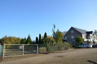 Dit gebouw met woon- en handelsfunctie ligt op een goede zichtlocatie en beschikt over een private parking aan de straatkant. De totale oppervlakte van de percelen bedraagt 1ha 11a 08ca. Het hoofdgebouw bestaat enerzijds uit een gelijkvloerse winkel met een oppervlakte van 200 vierkante meter en anderzijds uit een duplex appartement met een oppervlakte van 300 vierkante meter.<br />Naat het winkelgedeelte zijn er op het gelijkvloers een apart toilet, een kleine berging, een grote berging met functionerende koelcel, en een polyvalente ruimte met voorzieningen om de in te richten als studio (televisieaansluiting, wateraanvoer en -afvoer, elektriciteit).<br /><br />Het woongedeelte is zowel apart toegankelijk als via de winkel.<br />Het appartement baadt in het zonlicht. De grote raampartijen aan voor- en achterkant, het hoge plafond met mezzanine en de glazen deuren creëren een ruimtelijk gevoel en brengen extra lichtinval binnen. De ruime living met open keuken wordt verwarmd met vloerverwarming. Op het eerste verdiep bevinden zich verder een apart toilet, een slaapkamer met annex dressing (met aanwezige voorziening voor een badkamer), een tweede slaapkamer/bureau en een grote berging met de chauffageketel, een lavabo en de aansluiting voor een wasmachine.<br />Het volledige plat dak aan de keuken kan gebruikt worden als terras.<br /><br />Op het tweede verdiep bevindt zich links de masterbedroom met badkamer en ruimte voor een dressing. Rechts liggen 2 slaapkamers (met ingebouwde kasten, burelen en een wastafel), een apart toilet en een douchekamer.<br />De totale bruikbare vloer oppervlakte bedraagt 334m2 (bron EPC)<br /> <br />De betegelde serre grenst aan het hoofdgebouw. De kweekserre grenst aan een vrijstaand bijgebouw met verschillende bureelruimtes.<br /><br />Omwille van de ligging in agrarisch gebied, moet het pand een agrarische functie behouden. Mits functiewijziging kan het ook aangewend worden als paardenhouderij, manège, dierenasiel, dierenartsenpraktijk, jeugdlogies, tuinaanlegbedrijf, kinderboerderij, centrum voor dierentherapie, een instelling waar personen al dan niet tijdelijk verblijven bij wijze van therapie, onderwijs, opleiding of voorbereiding op de reguliere arbeidsmarkt die onder meer land- en tuinbouwactiviteiten uitoefenen of aan land- en tuinbouw verwante activiteiten uitoefenen.