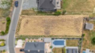 <p>Op een aangename en rustige ligging in Ophasselt bevindt zich deze mooie bouwgrond, <strong>lot 6 van een goedgekeurde verkaveling</strong>, bestemd voor het oprichten van een <strong>vrijstaande eengezinswoning</strong>. De ligging combineert rust met een goede bereikbaarheid. Winkels, openbaar vervoer en andere voorzieningen bevinden zich in de nabije omgeving, terwijl de verbindingswegen richting <strong>Geraardsbergen, Brakel en Ninove</strong> vlot bereikbaar zijn. Volgens de geldende verkavelingsvoorschriften is het perceel bestemd voor een vrijstaande eengezinswoning, waarbij de voorgevelbouwlijn op 5 meter achter de rooilijn ligt. De maximale bouwdiepte bedraagt 15 meter op het gelijkvloers en 12 meter op de verdieping. De bouwbreedte bedraagt 9.60 meter en de perceelbreedte +/- 15.60 meter. De kroonlijsthoogte dient tussen 3,40 meter en 6 meter te liggen en de woning wordt voorzien van een hellend dak met gelijkhellende dakvlakken en een dakhelling tussen 35° en 45°. Een garage kan worden geïntegreerd in het hoofdgebouw of, onder de voorwaarden van de verkavelingsvoorschriften, als afzonderlijke garage of bijgebouw worden opgericht met een maximale oppervlakte van 40 m². Een interessante bouwgrond voor wie op zoek is naar een <strong>ruime vrijstaande woning op een rustige locatie</strong>, met tegelijkertijd een vlotte strategische verbinding.</p>