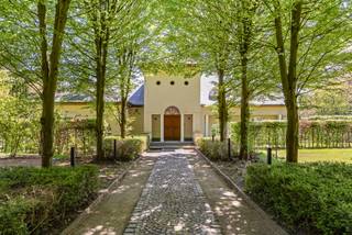 Exclusieve villa in groene oase in Herenthout
Locatie:
Gelegen langs de Itegemse Steenweg in Herenthout met een vlotte verbinding naar omliggende gemeenten en voorzieningen. U geniet hier van rust en privacy op een uitzonderlijk perceel van ca. 1 hectare met zwembad en vijvers.
Indeling:
De woning verwelkomt u via een ruime inkomhal met veel lichtinval. Op het gelijkvloers vindt u twee volwaardige slaapkamers, een badkamer uitgerust met ligbad, douche en dubbele wastafel, evenals een aangename leefruimte waar grote raampartijen zorgen voor een open en lichtrijk gevoel. De keuken kijkt uit op de tuin en staat in directe verbinding met de leefruimte. Verder beschikt deze verdieping over een praktische berging en een inpandige garage.
De bovenverdieping biedt plaats aan vier ruime slaapkamers en een tweede badkamer met douche, lavabo en toilet. Daarnaast is er een ruime overloop aanwezig die perfect kan ingericht worden als bureauruimte, hobbyhoek of speelkamer voor kinderen. Verder is de woning deels onderkelderd met zowel een kruipruimte als een bruikbare kelder.
Troeven:
• Perceel van ca. 1 hectare
• Zwembad en vijvers
• 6 slaapkamers
• Veel lichtinval
• Polyvalente overloop
• Garage en parkeergelegenheid
Technisch:
Solide constructie met grote raampartijen en houtkachel. Deels onderkelderd. Info op aanvraag.
Geniet van 2% verkooprechten bij aankoop als enige woning.
Bel 03/345.88.99 voor meer info.