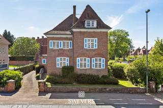 Voor meer info en foto’s, surf naar www.swevers.be – vlak aan de B-mine in Beringen bevindt zich deze karaktervolle ingenieurswoning terug. Een statige open bebouwing met een bewoonbare oppervlakte van 269 m², gelegen op een ruim perceel van 1.032 m². De woning uit 1930 biedt een uitstekende basis voor wie op zoek is naar veel ruimte en de mogelijkheid om volledig naar eigen smaak op te frissen. Via de inkomhal bereikt u de leefruimtes op het gelijkvloers. Hier vindt u een voorkamer die ideaal is als bureau of speelkamer, een ruime salon, een woonkamer van samen circa 42 m² en een keuken van ongeveer 15,6 m² met aansluitende berging en toegang tot tuin. Verder zijn er twee aparte toiletten aanwezig. Op de eerste verdieping bevinden zich drie ruime slaapkamers van circa 23 m², 18,75 m² en 15,6 m², evenals een badkamer met douche, ligbad, toilet en wastafel. De tweede verdieping biedt nog twee extra kamers onder het dak, bereikbaar via een vaste trap. Deze ruimtes kunnen perfect ingericht worden als bijkomende slaapkamers, hobbyruimte of bureau. In totaal beschikt de woning over vijf slaapkamers. Extra bergruimte is voorzien in de ruime kelder van ongeveer 83 m² met meerdere praktische ruimtes. Daarnaast is er een vrijstaande garage aanwezig. De westgerichte tuin biedt volop mogelijkheden om een aangename buitenruimte te creëren waar u optimaal van de namiddag- en avondzon geniet. De ligging vormt een extra troef met openbaar vervoer op 100 meter, scholen op 800 meter, restaurants op 450 meter, winkels op 2,4 kilometer en een vlotte verbinding naar de autosnelweg op slechts 2 kilometer. Bovendien ligt de populaire B-Mine-site recht tegenover de woning. Voor meer informatie, bel 011 255 155. Bron bewoonbare oppervlakte: EPC – verslag. Dit pand is onderworpen aan de renovatieverplichting van de Vlaamse overheid voor residentiële gebouwen (behoudens bij sloop binnen 5 jaar na de aankoop). Consulteer voor meer informatie de website van het Vlaams Energie- en Klimaatagentschap via https://www.vlaanderen.be/een-huis-of-appartement-kopen/renovatieverplichting-voor-residentiele-gebouwen.