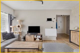 <strong>Immo Van Middelem verkoopt dit ruime (+/- 115 m²), instapklare gelijkvloers appartement met 2 kamers, zuid-geöriënteerde tuin, kelder en ondergrondse staanplaats, op wandelafstand van het CENTRUM van Dilbeek.</strong><br /><br />Het is gelegen op de GELIJKVLOERSE verdieping van goed onderhouden gebouw in een rustige woonwijk met uitsluitend plaatselijk verkeer. Op wandelafstand vind je winkels, scholen, restaurants en openbaar vervoer. De Brusselse Ring ligt op amper 1,5km. Een TOPLOCATIE, dus! <br /><br />De indeling is als volgt:<br />- ruime inkomhal met vestiaire en WC, badkamer met douche in bad, slaapkamer 1 met toegang tot de tuin, grote living (salon en eetplaats) met toegang tot de tuin, keuken met berging.<br />- via een trap in de living daalt u af naar slaapkamer 2 (kelderniveau).<br />- op de -1 beschikt u nog over een gemeenschappelijke wasplaats, een fietsenstalling, een privatieve kelderruimte en een privé-staanplaats. <br /><br />Gemeenschappelijke lasten: ± 120/maand<br />- onderhoud en schoonmaak gemene delen + lift;<br />- voorschot verbruik water;<br />- blokpolis;<br />- syndicus;<br /><br />Centrale verwarming op elektriciteit. <br />EPC: 348 kWh/m².jaar - Label D (UC: 2898664). <br />Elektriciteit CONFORM tot 2051! <br />Vrij bij akte.
