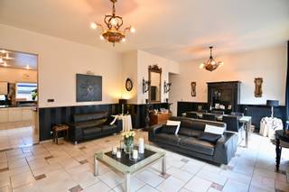 Deze knappe, instapklare stadswoning met een grote handelsruimte is gelegen in het hartje van Sint-Truiden, op wandelafstand van de Grote Markt en het station. Het pand werd volledig nieuw opgetrokken in 1994, met respect qua gevel en hoogte voor de omliggende herenwoningen. Het geheel werd opgericht met degelijke materialen, is steeds goed onderhouden, al kan het hier een daar een lichte opfrissing genieten. <br /><br />Zowel de woning als het handelsgedeelte beschikken over een aparte ingang in het overdekt portaal aan de straatzijde. Tevens hebben ze ieder een aparte elektriciteitsmeter. Hierdoor zouden beide delen autonoom van elkaar kunnen fungeren, mits het verkrijgen van de nodige toelatingen van het stadsbestuur.<br /><br />Het pand beschikt op het gelijkvloers over een grote handelsruimte van ca. 100m<sup>2</sup>, voorzien van een bijkeuken/wasplaats, alsook een apart gastentoilet en een extra buitenruimte. Momenteel is het geheel ingericht als kapsalon, voorzien van 6 kaptafels, 2 wastafels, een balie en een zit- en wachtruimte. Uiteraard kan dit handelsgedeelte ook voor andere doeleinden ingericht worden. Het pand zou eventueel als kangoeroewoning ingericht kunnen worden, mits toestemming van de gemeente.<br /><br />Het woongedeelte start eveneens op het gelijkvloers. We vinden er de inkomhal/traphal, een ruime garage, een CV-ruimte, en een rechtstreekse gang naar het handelspand. De eerste verdieping is ingedeeld met een leefruimte van ca. 42m<sup>2</sup> met balkon en knappe schouw, een grote leefkeuken, een apart gastentoilet en een slaapkamer/bureau, momenteel ingericht als TV-kamer, maar in te richten naar wens. In aansluiting van de leefkeuken is er een ruim terras dat deels afgesloten is en als veranda fungeert. De zijwand van de veranda, aan de kant van het open terras, kan open geschoven worden.<br /><br />Op de tweede verdieping vinden we een dressing-/bureauhoek (nog in te richten), drie ruime slaapkamers en een grote, ingerichte badkamer. De badkamer is voorzien van een ligbad, een douche, een toilet en een groot dubbel lavabomeubel. <br /><br />Nog meer ruimte nodig? De zolder, momenteel te bereiken via een vlizotrap, kan volledig ingericht worden als extra kamers of leefruimten. Elektriciteit werd hier reeds voorzien.<br /><br />Interesse in deze opportuniteit? Bel ons op 011 70 70 19 voor een afspraak ter plaatse.