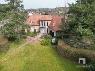 <p><span>Deze prachtige villa gelegen op de rand van het natuurgebied Gerhagen op 2km van het centrum van Tessenderlo is gelegen op een grondoppervlak van 1529 m². </span></p><p><span>Deze woning biedt een indrukwekkende bewoonbare oppervlakte van 332 m² en is voorzien van 4 ruime slaapkamers (5 mogelijk) en 2 stijlvolle badkamers, perfect voor een groot gezin of om gasten te ontvangen.</span></p><p><span> </span></p><p><span>Bij aankomst wordt u begroet door een uitnodigende oprijlaan en een prachtig aangelegde tuin die privacy en rust verzekeren. De voortuin is een groen paradijs en biedt een idyllische eerste indruk.</span></p><p><span> </span></p><p><span>Binnenin vindt u een royale inkomhal die overloopt in een ruime en elegante leefruimte. Deze ruimte is voorzien van grote ramen die voor een overvloed aan natuurlijk licht zorgen. De leefruimte is smaakvol ingericht en leidt naar een aparte eetkamer, ideaal voor feestelijke diners.</span></p><p><span> </span></p><p><span>De keuken is modern ingericht en uitgerust met alle nodige toestellen, wat koken tot een plezier maakt. Van hieruit heeft u een prachtig uitzicht op de tuin, die perfect is voor buiten dineren met een stijlvolle patio gevoel.</span></p><p><span> </span></p><p><span>De eerste verdieping bevindt een luxueuze masterbedroom met een eigen dressing. De overige slaapkamers zijn ruim en veelzijdig in gebruik, met een slaapkamer die uitkomt op een charmant terras, perfect voor het ontwaken op een zomerochtend.</span></p><p><span> </span></p><p><span>Extra voorzieningen zijn onder andere twee ruime garages, ideaal voor autoliefhebbers of extra opslag. De kelder is droog en netjes afgewerkt, wat voor extra opslagruimte zorgt.</span></p><p><span> </span></p><p><span>Dit huis belichaamt stijl en comfort en is omgeven door een weelderige tuin, wat bijdraagt aan de landelijke charme. Een pareltje voor wie op zoek is naar een mix van luxe en sereniteit. Mis deze unieke kans niet!</span></p><p><span> </span></p><p><span>TIP in drie stappen naar een EPC met label A/B :</span></p><p><span>- Plaats voor 4.000 Wp aan zonnepanelen = EPC 353kwh/m2 </span></p><p><span>- Plaats bijkomend 20 cm mineraal wol = EPC 309kwh/m2  </span></p><p><span>- CV op stookolie vervangen door gas =  EPC 245kwh/m2 of label C</span></p><p><span>- CV op stookolie vervangen door warmtepomp =  EPC 200kwh/m2 of label A of B</span></p><p><span> </span></p><p><span>Bel Immo Diest 013/31.25.22, wij helpen u verder met de glimlach.</span></p>