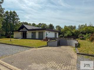 Deze gelijkvloerse woning is mooi en rustig gelegen op een perceel van 8a 90 ca met uitstekende verbindingen naar de omliggende steden en de snelwegen.<br /><br />Via de inkomhal komen we aan de linkerzijde van de woning in de ruime leefruimte waar de inbouwcassette voor een gezellige warmte kan zorgen.<br />Naast de eethoek bevindt zich de keuken met naastliggende berging. De nachthal biedt toegang tot de 3 slaapkamers ( waarvan er momenteel 2 zijn ingericht als één grote kamer), de badkamer en het gastentoilet. <br /><br />De kelder is bereikbaar via de trap vanuit de berging of ook met de wagen via de inrit naast de woning.<br />De kelder strekt zicht uit onder de ganse woning en is opgedeeld in verschillende kamers, waaronder een ruime garage die plaats biedt aan meerdere wagens. De garagepoorty is elektrisch bedienbaar.<br />De ramen aan de woning zijn voorzien van rolluiken.<br /><br /><em><span>*De vermelde oppervlaktes zijn indicatief. JM Vastgoed kan niet verantwoordelijk gesteld worden voor de juistheid van de verstrekte gegevens.</span></em>