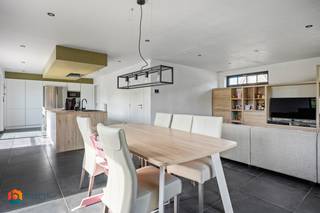 Op een uitstekende locatie in Beerzel (Putte) bevindt zich deze recente villa op een ruim perceel van 825 m². De woning geniet van een rustige, residentiële ligging met een vlotte bereikbaarheid, vlak bij winkels, scholen, openbaar vervoer en invalswegen. Dankzij de polyvalente ruimte met aparte ingang is dit de ideale woning voor wie wonen en werken wil combineren.<br /><br />We betreden de woning via de inkomhal met gastentoilet. De lichtrijke leefruimte met open, volledig ingerichte keuken, vormt het hart van de woning en is uitgerust met een inductiekookplaat, oven, dampkap en ingebouwde vaatwasser. Grote raampartijen over de volledige breedte zorgen voor een mooi zicht op het zonnige, westgerichte terras en de volledig omheinde tuin. Aansluitend bevindt zich nog een praktische berging.<br /><br />De polyvalente ruimte van ca. 28 m² met eigen inkom, wachtruimte en toilet is ideaal als praktijk, kantoor of hobbyruimte.<br /><br />Via de nachthal bereiken we vier ruime slaapkamers en een badkamer met inloopdouche, dubbele lavabo en toilet. Een bergzolder zorgt voor extra opbergruimte.<br /><br />Met een bewoonbare oppervlakte van 221 m² en een EPC-label A (51 kWh/m²) biedt deze woning alle hedendaagse comfort. Dak- en vloerisolatie, driedubbele beglazing en zonnepanelen zorgen voor een bijzonder laag energieverbruik.<br /><br />Bent u op zoek naar een recente, energiezuinige villa met praktijkruimte op een rustige locatie in Beerzel? Contacteer ons via 0474/78 07 73 of www.boonstravastgoed.be<br /><br />Bijzonderheden:<br />• 221 m² bewoonbaar<br />• EPC-label A (51 kWh/m²)<br />• Praktijkruimte met aparte ingang