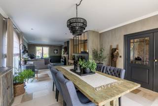 Deze sfeervolle en uitstekend onderhouden woning is rustig en kindvriendelijk gelegen in Mol-Gompel, op fietsafstand van lokale winkels en het centrum. Dankzij de vlotte verbinding zijn ook de omliggende gemeenten en de E313 en E34 snel bereikbaar.<br /><br />Via de inkomhal, met gastentoilet en vestiaire, kom je in de ruime en lichtrijke leefruimte. Deze is opgedeeld in een gezellige zithoek, eethoek en bureauruimte. Grote raampartijen zorgen voor een aangename lichtinval en een mooi zicht op de tuin. De parketvloer, Bourgondische dallen, maatkasten en venstertabletten in oude eiken wagonplanken en de pelletkachel geven het geheel een warme en karaktervolle uitstraling.<br /><br />De leefkeuken vormt het hart van de woning en is uitgerust met een kwalitatief Lacanche-kookfornuis met twee afzonderlijke ovens. Daarnaast beschikt de keuken over een vaatwasser, microgolfoven, koelkast, dubbele spoeltafel, natuurstenen werkbladen en voldoende kastruimte. De gezellige ontbijt- en eethoek biedt opnieuw een mooi zicht op de tuin. Aansluitend bevindt zich een praktische wasplaats/berging met douche, uitgietbak, extra toilet en handige inbouwkasten.<br /><br />Op de eerste verdieping geeft de nachthal toegang tot drie ruime slaapkamers, die allemaal voorzien zijn van airconditioning. De twee achterste slaapkamers beschikken bovendien over elektrische rolluiken. De masterbedroom heeft een eigen dressingruimte. De badkamer is ingericht met een ruime inloopdouche, ligbad en dubbele wastafel in meubel met arduinen blad. Op de nachthal bevindt zich tevens een apart toilet.<br /><br />Via een vaste trap bereik je de zolderverdieping, die in 2025 volledig werd afgewerkt. Deze ruimte beschikt over nieuwe vloeren, maatkasten en een dakraam en biedt daarnaast nog een extra berging en ruimte voor de technische installaties.<br /><br />De woonkamer, keuken en badkamer werden recent afgewerkt met kwalitatieve kalkverf, wat bijdraagt aan de warme en natuurlijke uitstraling van de woning.<br /><br />Op het gelijkvloers is vloerverwarming voorzien; de verdieping en zolder worden verwarmd via radiatoren. De woning beschikt over een ventilatiesysteem type D met warmterecuperatie, 16 zonnepanelen en een goede isolatie, wat resulteert in een gunstig EPC-label.<br /><br />Ook de buitenomgeving werd met veel aandacht aangelegd. De verzorgde tuin beschikt over een terras dat rechtstreeks aansluit op de keuken en een prachtig eiken tuinpaviljoen. Het paviljoen werd afgewerkt met hoogwaardige materialen, waaronder een arduinen vloer, Bourgondische tegelpannen, stalen ramen en een kachel. Het vormt een heerlijke plek om in alle rust van de tuin te genieten.<br /><br />Verder zijn er een aparte tuinberging, buitendouche en beregeningsinstallatie aanwezig. De woning beschikt daarnaast over een ruime garage met automatische sectionaalpoort. Het volledig omheinde perceel wordt aan de voorzijde afgesloten met een automatische houten toegangspoort in afromosia.<br /><br />Een bijkomende troef is de mogelijkheid om het naastgelegen perceel, dat momenteel deel uitmaakt van het geheel, mee aan te kopen voor € 180.000. Op dit perceel is een halfopen bebouwing mogelijk, wat interessante mogelijkheden biedt voor wie extra ruimte of een toekomstige bouwmogelijkheid of investering wenst.<br /><br />Ben je op zoek naar een ruime, karaktervolle en kwalitatief afgewerkte woning waar comfort, rust en sfeer hand in hand gaan? Dan is deze woning in Gompel absoluut een bezoek waard.