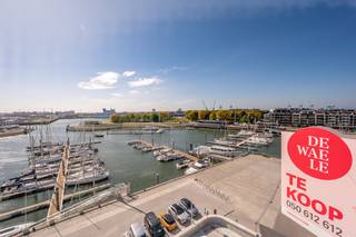 OPENDEURDAG 12/09 VAN 13U - 15U<br /><br /><br />Dit energiezuinig appartement (EPC A) te koop is gelegen langs de jachthaven van Zeebrugge in een recente residentie. Met een bewoonbare oppervlakte van 128m² geniet je hier van ruimte, licht en een moderne afwerking. Het appartement bevindt zich op de zesde verdieping en beschikt over twee zonnige terrassen, waarvan één zuidwest gericht met een prachtig uitzicht over de jachthaven. Dankzij deze oriëntatie kan je tot laat in de avond genieten van zon en zeezicht.<br /><br />Binnenin vind je twee volwaardige slaapkamers, elk voorzien van een eigen badkamer, wat dit appartement ideaal maakt voor zowel gezinnen als koppels die comfort en privacy waarderen. De grote leefruimte met aansluitende keuken sluit naadloos aan op het terras en creëert een open gevoel dat perfect past bij de omgeving. Daarnaast zijn er tal van ingemaakte kasten en een dressing. <br /><br />Indeling: <br />- inkomhall met vestiaire en gastentoilet<br />- leefruimte met zit- en eetplaats<br />- terras aanpalend aan de leefruimte met zicht op jachthaven<br />- berging<br />- slaapkamer 1 <br />- badkamer bestaande uit inloopdouche, dubbele wastafel en toilet<br />- nachthall met ingemaakte kasten<br />- masterbedroom met terras en ensuite badkamer bestaande uit dubbele wastafel en inloopdouche <br />- gemeenschappelijke fietsenberging en tuin<br /><br />Tevens is er een mogelijkheid tot aankoop van een dubbele garagebox in de residentie. <br /><br />Ideaal aanbod voor wie op zoek is naar een vaste woonst of tweede verblijf aan de Belgische Kust! <br /><br />Bezoek warm aanbevolen! <br /><br />Bestuursmaatregelen in het maatregelenregister: nee<br /><br />Deze AI-visualisaties zijn bedoeld als inspiratie. Er werd geen rekening gehouden met technische specificaties, stedenbouwkundige voorschriften of de concrete mogelijkheden tot realisatie.