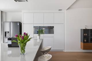 Achter de gevel van Residentie Mondriaan schuilt een bijzonder ruim appartement waar de buitenruimte meteen de toon zet. Een royaal, zuidgericht dakterras van 100 m², groen aangelegd met niet-woekerende bamboe, olijfbomen en lavendel, met charmant open zicht op de kerktoren.<br /><br />Gelegen in een kleinschalige residentie beschikt het appartement over een bruto bewoonbare oppervlakte van circa 185 m² en is volledig instapklaar. De voorgevel verwijst subtiel naar het werk van kunstschilder Piet Mondriaan en geeft het gebouw een herkenbare signatuur.<br /><br />Bij aankomst brengt de privétoegang via de lift u rechtstreeks in het appartement. Ingebouwd kastwerk bij de lift zorgt voor een verzorgde en praktische ontvangst. Van daaruit opent het geheel zich naar een ruime leefruimte, waar licht, volume en rust samenkomen.<br /><br />De doorlopende eiken parketvloer, het witte maatwerk en de kwaliteitsdeuren zorgen voor een rustig interieur. Brede raampartijen met hoogrendementsglas brengen het daglicht rijkelijk binnen en versterken het ruimtelijke gevoel. Eetruimte, salon en bureauruimte vormen samen één open leefomgeving, met het royale terras als natuurlijk verlengstuk. In de leefruimte is bovendien de mogelijkheid voorzien om een gashaard aan te sluiten. <br /><br />De keuken sluit volledig aan op de leefruimte en is strak opgevat met wandkasten, een kookeiland met een werkblad van maar liefst 5 m, ingewerkte lades en ingebouwde toestellen van onder meer Smeg en Siemens. <br /><br />Het terras vormt de uitgesproken meerwaarde van dit appartement. Door de oppervlakte, de zuidgerichte oriëntatie en de groenaanleg ontstaat een buitenruimte die verder gaat dan een klassiek terras. De antislip terrastegels, lavendel, niet-woekerende bamboe, olijfbomen, stroomaansluitingen en automatische bewatering maken deze plek geschikt voor dagelijks gebruik, lange avonden buiten en genieten van alle rust en gezelligheid. <br /><br />Het slaapgedeelte is apart ingedeeld. Beide slaapkamers beschikken over een eigen badkamer met wastafelmeubel en inloopdouche. De master heeft daarnaast een ligbad, ingebouwde maatkasten en toegang tot een afzonderlijk balkon. Beide slaapkamers zijn voorzien van extra comfort, waaronder airco of warmtebron en tv-aansluiting. Ook aan praktische details werd gedacht, zoals vliegenramen.<br /><br />Technisch is het appartement optimaal en zorgvuldig uitgerust met automatische screens, ventilatie type C die zich automatisch aanpast, brandalarm, jaarlijks gecontroleerde brandbeveiliging, een Viessmann-gasketel en een berging met aansluitingen voor wasmachine en droogkast.<br /><br />Verder beschikt het appartement over EPC-label A met een energiescore van 84 kWh/m² jaar. <br /><br />Ondergronds is een privatieve staanplaats inbegrepen.<br /><br />Een bijzonder ruim en energiezuinig appartement met een royale private buitenruimte die de woonbeleving hier op een uitzonderlijke manier versterkt.
