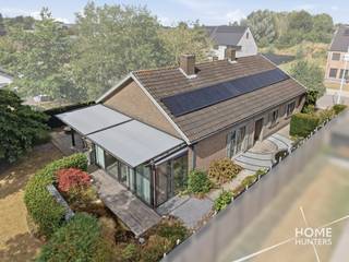 Op zoek naar een instapklare &amp; gelijkvloerse woning waar ruimte en kwaliteit centraal staan? Dan is deze smaakvol afgewerkte open bebouwing absoluut een bezoek waard. De woning beschikt over royale leefruimtes, een prachtige architecturaal aangelegde tuin en een hoogwaardige afwerking. Dit alles op een rustige ligging op wandelafstand van winkels en scholen.<br /><br />Bij het betreden van de woning komt u terecht in een ruime inkomhal met twee praktische inbouwkasten. De lichtrijke leefruimte vormt samen met de gezellige veranda het hart van de woning. De veranda is uitgerust met dubbele beglazing, automatische ventilatie en elektrische zonwering en biedt een prachtig uitzicht op de architecturaal aangelegde zuidwest-gerichte tuin met sierlijke vijvers. Ook buiten geniet u optimaal dankzij de pergola met zonwering, de barbecue met pizzaoven en de sfeervolle tuinverlichting.<br /><br />De kwalitatieve eiken keuken met duurzaam Dekton werkblad beschikt over heel wat kastruimte en is volledig uitgerust met ingebouwde toestellen. Aansluitend bevindt zich een gezellige eethoek en een praktische berging.<br /><br />Verder beschikt de woning over drie volwaardige slaapkamers met inbouwkasten, een aparte bureau of polyvalente ruimte, een stijlvolle badkamer met douche, ligbad, nieuw hangtoilet en ventilatie, evenals een ruime garage.<br /><br />Een absolute troef is de enorme zolderverdieping met een vrije stahoogte van ongeveer 2 meter. Deze biedt tal van mogelijkheden voor het creëren van extra slaapkamers, hobbyruimte of een thuiskantoor.<br /><br />Ook op technisch vlak scoort deze woning uitstekend. Zo beschikt ze over 16 zonnepanelen (5.120 kWh), een recente condenserende aardgasketel, overal dubbele beglazing, geïsoleerde buitenmuren en zoldervloer, een regenwaterput van 10.000 liter met drievoudig filtersysteem, een gekeurd alarmsysteem en een verandascreen.<br /><br />Extra troeven:<br /><br />- Open bebouwing met veel privacy<br />- Architecturaal aangelegde Zuidwest-gerichte tuin<br />- Drie slaapkamers met inbouwkasten<br />- Mogelijkheid tot extra kamers op de zolder<br />- Ruime garage, tuinhuis en fietsenberging<br />- Open haard<br />- 16 zonnepanelen<br />- EPC-label C (278 kWh/m²) – geen renovatieverplichting<br />- Asbestveilig attest beschikbaar<br />- Geen aanwijzingen van bodemverontreiniging<br />- Overstromingsscore A voor zowel perceel als woning<br />- Rustige ligging op wandelafstand van winkels en scholen<br /><br />Een woning waar ruimte en een uitzonderlijke tuin samenkomen. Ideaal voor wie zonder zorgen wil verhuizen naar een kwalitatieve gezinswoning met alle comfort en uitbreidingsmogelijkheden.