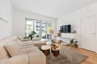 <h2><span>Licht, luxe en buitenleven aan de Slachthuissite</span></h2><p><span>Aan de Eugène De Plynstraat, in de nieuwe en groene Slachthuisbuurt, bevindt zich dit bijzonder lichtrijke appartement van 97 m² met twee slaapkamers en een royaal terras.</span></p><p><span>De leefruimte geniet dankzij de brede raampartijen van veel natuurlijk licht. De grote troef is zonder twijfel het terras, dat als een volwaardige uitbreiding van de woonkamer aanvoelt. Er is voldoende plaats voor een grote eettafel, een comfortabele loungehoek en extra groen. Van hieruit kijkt u uit over de fraai aangelegde binnentuin. Een rustige en groene omgeving midden in de stad.</span></p><p><span>De open keuken vormt het stijlvolle hart van het appartement. Warme fronten in notenhoutlook worden gecombineerd met strakke witte elementen, een licht werkblad met marmertekening, geïntegreerde toestellen en een ruime ontbijtbar. De designkraan maakt het geheel helemaal af.</span></p><p><span>Ook de rest van het appartement werd bijzonder doordacht ingericht. In de inkomhal bevindt zich een royale kastenwand op maat met geïntegreerde zitbank. Verder zijn er twee slaapkamers, een badkamer, een afzonderlijk toilet en praktische bergruimte.</span></p><p><span>Dankzij de vloerverwarming geniet u tijdens de winter van een aangename en gelijkmatige warmte. In de zomer zorgt de vloerkoeling voor extra wooncomfort, zonder storende radiatoren of klassieke aircotoestellen.</span></p><p><span>Bij het appartement hoort een prive kelderberging op niveau -1. De residentie beschikt bovendien over een lift.</span></p><p><span>De ligging combineert rust en stadsleven. Park Spoor Noord, het Eilandje, winkels, horeca, openbaar vervoer en belangrijke invalswegen bevinden zich vlakbij.</span></p><h3><span>Troeven</span><span><br />Royaalterras met zicht op de groene binnentuin<br />Veel natuurlijke lichtinval<br />Hoogwaardige open keuken met ontbijtbar<br />Vloerverwarming en vloerkoeling<br />Maatkasten met geïntegreerde zitbank<br />Badkamer en afzonderlijk toilet<br />Prive kelderberging<br />Lift aanwezig<br />Recent gebouw uit 2025</span></h3><p><span> </span></p><p><span>Contacteer ons voor meer informatie of een bezoek ter plaatse.</span></p>