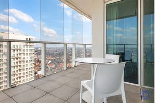 <p><span>Panoramisch wonen op de 18de verdieping aan het Eilandje</span></p><p><span>Op zoek naar een lichtrijk appartement met een uitzicht waar slechts weinigen van kunnen dromen? Op de 18de verdieping van een verzorgd appartementsgebouw aan de Ellermanstraat 61 bevindt zich dit aangename twee slaapkamerappartement met een indrukwekkend panoramisch zicht over de Antwerpse skyline en de dokken.</span></p><p><span>De lichtrijke leef- en eetruimte van ca. 32 m² wordt omringd door grote raampartijen en biedt voldoende plaats voor een comfortabele zit- en eethoek. Vanuit vrijwel elke hoek geniet u van het voortdurend veranderende uitzicht over Antwerpen. Aansluitend bevindt zich de volledig ingerichte open keuken, voorzien van een inductie kookplaat, dampkap, koelkast met diepvriesvak, microgolf en vaatwasser.</span></p><p><span>Het appartement beschikt over twee slaapkamers van respectievelijk ca. 12 m² en 9 m². De badkamer is uitgerust met een regendouche, lavabomeubel, spiegel en toilet. Daarnaast is er een extra, praktische berging met aansluitingen voor een wasmachine en droogkast.</span></p><p><span>Een absolute blikvanger is het royale terras dat zich rondom het appartement uitstrekt. Hier geniet u op verschillende momenten van de dag van de zon, de rust op hoogte en een uniek uitzicht over de stad en haar dokken.</span></p><p><span>Het appartement is volledig rolstoeltoegankelijk. Een privatieve parkeerplaats hoort bij het appartement en dient verplicht mee aangekocht te worden voor €30.000.</span></p><p><span> </span></p><p><span>Indeling</span></p><p><span>Lichtrijke leef- en eetruimte van ca. 32 m² met toegang tot het panoramisch terras van ca. 29m²</span></p><p><span>Volledig ingerichte open keuken voorzien van een inductie kookplaat, dampkap, koelkast met diepvriesvak, microgolf en vaatwasser.</span></p><p><span>Slaapkamer van ca. 12 m² op parketvloer met toegang tot het terras</span></p><p><span>Tweede slaapkamer van ca. 9 m² parketvloer met toegang tot het terras</span></p><p><span>Badkamer met inloop regendouche, lavabomeubel, spiegel en toilet</span></p><p><span>Extra berging met aansluitingen voor wasmachine en droogkast</span></p><p><span> </span></p><p><span>Belangrijkste troeven</span></p><ul><li><span>Gelegen op de 18de verdieping</span></li><li><span>Adembenemend uitzicht over Antwerpen en de dokken</span></li><li><span>Grote raampartijen en uitzonderlijk veel lichtinval</span></li><li><span>Royaal terras rondom het appartement</span></li><li><span>Twee slaapkamers</span></li><li><span>Volledig rolstoeltoegankelijk</span></li><li><span>Goed onderhouden gemeenschappelijke delen</span></li><li><span>Privatieve parkeerplaats verplicht mee aan te kopen</span></li></ul><p><span> </span></p><p><span>Algemene informatie</span></p><p><span>Elektriciteit met privatieve verbruiksmeter</span></p><ul><li><span>Elektrische installatie: conform</span></li><li><span>EPC: A-label </span></li><li><span>Asbestattest: niet van toepassing</span></li></ul><p><span> </span></p><p><span>Het gebouw</span></p><p><span>Het kwalitatieve en goed onderhouden appartementsgebouw omvat een ondergrondse verdieping met parkeerplaatsen en bergingen, een gelijkvloerse verdieping en 21 verdiepingen met appartementen. Het gebouw beschikt over meerdere liften en een videofoonsysteem.</span></p><p><span> </span></p><p><span>Ligging</span></p><p><span>Het appartement bevindt zich op een uitstekende locatie nabij de Antwerpse dokken en het bruisende Eilandje. Winkels, scholen, horeca en openbaar vervoer liggen op wandelafstand. Ook het historische stadscentrum en de Antwerpse Ring zijn vlot bereikbaar.</span></p><p><span>Een uitzonderlijke woonplek voor wie ruimte, licht, comfort en een spectaculair uitzicht over Antwerpen weet te waarderen.</span></p><p><span> </span></p><p><span>De informatie in deze prospect is ter informatieve titel: de kandidaat-kopers moeten hun eigen zaak maken van het verkrijgen, controleren en interpreteren van deze informatie.</span></p><p><span> </span></p>