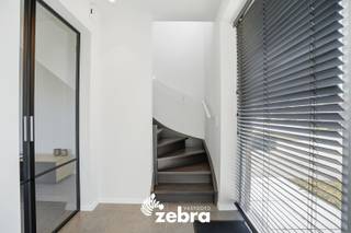 Deze instapklare kijkwoning met inpandige garage en vier slaapkamers bevindt zich in een rustige en aangename woonwijk aan de rand van Roeselare. Met haar moderne architectuur en stijlvolle uitstraling combineert de woning hedendaags wooncomfort met een groene en rustige omgeving, terwijl u toch geniet van een vlotte bereikbaarheid.<br /><br />Bij het binnenkomen komt u terecht in de inkomhal met apart gastentoilet. Aansluitend bevindt zich de ruime en lichtrijke leefruimte die naadloos overgaat in de volledig ingerichte keuken met kookeiland. De keuken is uitgerust met een vaatwasser, combi-oven, koelkast, kookplaat en dampkap. Verder beschikt het gelijkvloers over een inpandige garage.<br /><br />Op de eerste verdieping bevinden zich vier volwaardige slaapkamers, waaronder een ruime master bedroom met maatkasten. Daarnaast is er een ingerichte badkamer voorzien van een ligbad, doorloopdouche en dubbel lavabomeubel. Verder vindt u op deze verdieping nog een apart toilet en een praktische berging.<br /><br />De woning behaalt een uitzonderlijk laag E-peil van -7 dankzij de aansluiting op het stadswarmtenet, vloerverwarming en zonnepanelen van 5.600 WP.<br /><br />Tot slot beschikt de woning over een ruime tuin met terras, grenzend aan een groenzone. De woning wordt bovendien volledig bemeubeld verkocht.<br /><br />* Prijs excl. btw en kosten.<br /><br />Een vrijblijvend gesprek over dit project is mogelijk bij ons op kantoor.