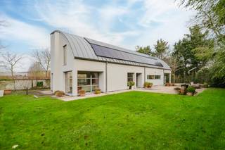 This unique villa with a living area of no less than 300m² is looking for its new residents! The location & cozy garden are just a few of the many advantages!<br /><br />The layout is as follows:<br />You will be welcomed into a spacious entrance hall, complete with cloakroom and separate guest toilet.<br /><br />The house has a bright living space with a view of the garden and the countryside, so you can fully enjoy the view of greenery. The adjoining dining area is spacious and attractive.<br /><br />The practical kitchen is fully equipped with all modern comforts (oven, steam oven, microwave, refrigerator, dishwasher and gas stove). Right next to it, there is a handy laundry room and extra storage space for optimal convenience.<br /><br />Thanks to the large windows and the well thought-out layout, each room enjoys pleasant light and a relaxing contact with the outside environment.<br /><br />On the first floor:<br />There is a very spacious office space that can perfectly serve as a second living space or hobby room. <br /><br />Through the night hall, you have access to 4 full bedrooms.<br /><br />There is a comfortable, large bathroom with a bath, shower and double sink.<br /><br />The house also has a sunny garden, a practical attic, many parking options and solar panels!<br /><br />Interested? Request a visit at www.dewaele.com