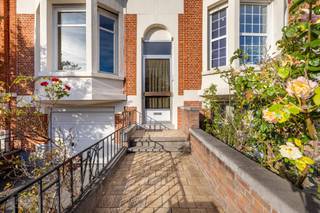 Met plezier stellen wij u deze prachtige en klassevolle herenwoning voor, gelegen op de Leuvense ring aan Naamsevest 34, op een toplocatie vlak bij belangrijke invalswegen, de Delhaize, bushaltes en het centrum van Leuven. De statige voorgevel spreekt meteen boekdelen en geeft deze woning een indrukwekkende, karaktervolle uitstraling. Parkeren kan bovendien voor de deur, op de eigen oprit én in de inpandige garage: een absolute zeldzaamheid in centrum Leuven. Met een bewoonbare oppervlakte van maar liefst 260 m² (ref. EPC) geniet u hier van een zee aan ruimte en talloze mogelijkheden, waaronder het creëren van maar liefst vijf slaapkamers. De woning heeft unieke elementen met onder meer een charmante erker aan de woonkamer, een balkonnetje, een royale trappenhal en een sierlijke inkomhal met niveauverschil. De indeling zit reeds goed; de keuken kijkt dankzij grote raampartijen uit op de aangename stadstuin met groen, een heerlijke buitenruimte in de stad. De ruime badkamer bevindt zich op het tussenverdiep richting de slaapkamers. Daarnaast beschikt de woning over zowel een kelder als een zolder, ideaal als praktische bergruimte. Dankzij EPC-label C geldt er geen renovatieverplichting, waardoor u gefaseerd en zonder tijdsdruk kunt moderniseren. Wie historiek, klasse en ruimte op een strategische locatie wil combineren, vindt hier een echte buitenkans en kan van deze woning een droomhuis maken. Interesse? Contacteer ons via info@homies.be of 016 22 82 22. (stedenbouw in aanvraag)