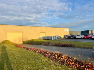 Samengesteld uit twee productiehallen van 933 m² en 1.000 m², met een vrije hoogte onder dak van ca. 5,50 m.
Vlotte toegang via twee sectionale poorten, waarvan één met inpandige laad- en loskade. De achterste hal is uitgerust met 6 airconditionings.
Een administratieve zone omvat:
een inkomhal,
twee kantoren,
een bergruimte,
sanitaire voorzieningen en kleedkamers H/D,
evenals een refter met kitchenette.
Het gebouw is opgetrokken in een betonnen structuur met gladde industriële betonvloer, betonnen gevels en een vlakke metalen dakconstructie. Verwarming via twee mazoutketels (kantoren en hallen).
Technische installaties aanwezig (elektriciteit, sanitair, alarm, hydranten).
Buiten: geasfalteerde parkeer- en toegangswegen, oprijlaan naar de laad- en loskade, groenzone.
👉 Functioneel bedrijfsgebouw met ruime volumes en groot potentieel voor industriële of logistieke activiteiten.