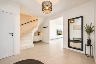 <p>Deze instapklare woning combineert grote leefruimtes met een praktische indeling en hedendaags comfort.<br />De woning heeft een energielabel “A” en is gelegen in een rustige, kindvriendelijke omgeving.</p>
<p><strong>GELIJKVLOERS</strong><br /><strong>Inkomhal van 20m²</strong> op tegel met gastentoilet en handenwasser.<br />De <strong>woonkamer van 50m²</strong> op tegel is voorzien van een TV-meubel en biedt via een grote schuifraam toegang tot de tuin.<br />Aansluitend bevindt zich de <strong>open keuken van 15m²</strong> met ontbijthoek en kookeiland. De keuken is uitgerust met een AEG-inductiekookplaat en geïntegreerde dampkap, een koelkast, vaatwasser, combi-oven, heteluchtoven en spoelbak.<br />De <strong>wasplaats van 13m²</strong> op tegel beschikt over aansluitingen voor wasmachine en droogkast en een ingebouwde kastenwand.<br />De volledig omheinde tuin beschikt over een <strong>terras van circa 30m².<br /></strong>De <strong>carport van 22m²</strong> is aangelegd met klinkers.</p>
<p><strong>1STE VERDIEPING</strong><br /><strong>De overloop van 10m²</strong> beschikt over een nachttoilet, linnenkasten en een technische ruimte.<br />De <strong>hoofdslaapkamer van 18m² </strong>heeft een aansluitende van <strong>dressing van 8m².</strong> De <strong>badkamer van 12m²</strong> is uitgerust met een ligbad, inloopdouche en dubbel lavabomeubel.<br />Verder zijn er nog een <strong>2<sup>de</sup> slaapkamer van 17m²</strong> en een <strong>3de slaapkamer van 19m².</strong></p>
<p><strong>BIJZONDERHEDEN<br /></strong>De vermelde “bewoonbare oppervlakte” is gebaseerd op de “bruikbare vloeroppervlakte” zoals vermeld in het EPC.<br /><strong></strong>Niko home control domotica-aansluiting, 19 zonnepanelen, vloerverwarming voor zowel verwarmen als koelen, dubbele beglazing, aluminium schrijnwerk, vaste vliegenhorren, aansluiting voor alarm en videofoon.</p>
<p><strong>POSITIEVE PUNTEN<br /></strong>Instapklaar<br />Energielabel “A”<br />Zéér goede bereikbaarheid<br />Kindvriendelijke omgeving<br />Gelegen in een doodlopende straat<br />Nabij winkels, scholen en openbaar vervoer</p>