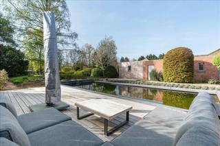 Exclusieve, hyper-geïnstalleerde woning (3 slpk.) met zwemvijver op een riant perceel van ca. 1.602 m², gelegen in een residentiële en groene omgeving.<br /><br />Deze energiezuinige woning met hoogwaardige afwerking heeft recente technieken zoals zonnepanelen (7,4 kVa), ventilatie C+ met extra's, een warmtepomp in combinatie met cv op gas, thuisbatterij en laadpaal (2025) evenals conforme elektriciteit (2026), behaalt de woning een uitstekende EPC-score van 114 kWh/m² . Alles met app-sturing.<br /><br />Ligging:<br />Rustig en residentieel met veel groen.<br /><br />Omschrijving:<br />De inkomhal met gastentoilet leidt naar de woonkamer en daarnaast de zitruimte met gezellige gashaard, met maatwerk en raambekleding gaat u naadloos naar de open keuken en ontbijthoek/veranda. Deze creëren een optimale connectie met de tuin en zwemvijver. Op het gelijkvloers treft u ook de kantoorruimte, deze heeft een rechtstreekse toegangsdeur van buitenaf met toegangscontrole en parking.<br /><br />De volledig uitgeruste leefkeuken met aparte ontbijthoek beschikt over recente, hoogwaardige toestellen en sluit aan op een praktische berging met wasplaats en douche. Het gelijkvloers, inclusief de kantoorruimte en de badkamer nivo 1, is voorzien van vloerverwarming.<br /><br />Op de verdieping geeft de nachthal toegang tot drie grote slaapkamers en een design badkamer. De masterbedroom wordt gekenmerkt door een open vide en een hoog plafond, wat zorgt voor een ruimtelijk gevoel. Alle kamers hebben recente ingemaakte kasten in lakwerk of houtfineer. Verder is er een handige kelder, afgewerkte zolder en is er buiten een ruime dubbele garage met automatische poort, deze zorgen voor een aanwezige opbergruimte. Verder aanwezig domotica, automatisch hekwerk en beveiliging.<br /><br />De volledig aangelegde tuin vormt een absolute troef: de ruime tuin met ideale zuid-oriëntatie biedt maximale zoninval en privacy. De zwemvijver en het groene uitzicht zorgen voor een unieke beleving, midden in een rustige en natuurlijke omgeving. Meer info www.heylenvastgoed.be<br />