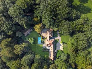 <p><span>Deze klassieke villa is gelegen op een AAA-locatie aan de Bellevuedreef te Schilde, nabij het park.</span></p><p><span>De omheinde tuin van ca. 1,4 Hectare biedt u alle rust en privacy. </span></p><p><span> </span></p><p><span>Indeling</span></p><p><span>U betreedt de villa middels de centrale inkomhal met vestiaire en gastentoilet alsook de trap naar de verdieping. Vanuit de inkomhal toegang tot de ruime leefruimte bestaande uit een zitkamer, een eetkamergedeelte met aansluitend een studeerkamer alsook vanuit de eetkamer toegang tot de ruime leefkeuken. Tevens vanuit de inkomhal toegang tot een ruim bureel met prachtige ingemaakte kasten. De leefkeuken bestaat uit een ontbijtkamer met grote schuiframen naar tuin en terras en een werkgedeelte met eiland en is voorzien van diverse inbouwtoestellen waaronder een Amerikaanse ijskast, combioven en stoomoven, etc. Vanuit de keuken een tweede doorgang naar de eetkamer via een berging en doorgang naar de bijkeuken met zij-inkom. </span></p><p><span> </span></p><p><span>Verdieping</span></p><p><span>De nachthal geeft toegang tot een ruime slaapkamer met eigen badkamer, een logeerkamer met eveneens een eigen badkamer, derde ruime kinderkamer met opnieuw een eigen badkamer. De mastersuite omvat een ruime slaapkamer, dressingkamer en een luxe badkamer. Vanuit de mastersuite doorgang naar de tussengang en diensttrap naar conciërgegedeelte. </span></p><p><span> </span></p><p><span>Garage</span></p><p><span>Inpandige garage voor drie wagens voorzien van automatische poorten. </span></p><p><span> </span></p><p><span>Conciërgewoning</span></p><p><span>Boven de garage bevindt zich een conciërgewoning welke bestaat uit een polyvalente ruimte, slaapkamer en badkamer. </span></p><p><span> </span></p><p><span>Kelder</span></p><p><span>U bereikt de kelder middels een draaiende trap uit natuursteen, de kelder biedt bergruimte, technische ruimte voor CV en zwembad alsook een fraaie wijnkelder. </span></p><p><span> </span></p><p><span>Poolhouse</span></p><p><span>Het grote bijgebouw werd gebouwd in dezelfde materialen als de villa en biedt een volwaardig gastenverblijf met woonkamer, keuken, slaapkamer en badkamer. </span></p><p><span> </span></p><p><span>Bijzonderheden </span></p><p><span>De villa werd gebouwd in 1978 en in 1996 vond een uitgebreide renovatie plaats met vervolgens regelmatige onderhouds- en opfrissingswerken. Er is een verwarmd zwembad aanwezig, ruime terrassen, aangelegde en omheinde tuin met tuinverlichting. De woning is zeer goed beveiligd en voorzien van alarm, camerabewaking etc.</span></p><p><span> </span></p><p><span>Meer inlichtingen via ons kantoor.</span></p>