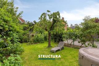 In een rustige doodlopende straat in Wemmel bevindt zich deze verrassend ruime halfopen bebouwing op een perceel van ca. 3a63ca. Met een bewoonbare oppervlakte van ongeveer 204 m², een praktische indeling over verschillende niveaus, een groene tuin met veel privacy en een uitstekende energiescore (EPC B) dankzij de zonnepanelen en thuisbatterij, biedt deze woning een ideale combinatie van ruimte, comfort en energiezuinig wonen.Indeling- Gelijkvloers: via de inkomhal betreedt u de woning. Op deze verdieping bevinden zich een afzonderlijk toilet, een wasberging met douche, een kelderberging, de garage en een extra kamer die perfect kan dienen als slaapkamer, bureau of hobbyruimte.- Eerste verdieping: deze vormt het hart van de woning en omvat een aangename leefruimte met gezellige cassettehaard op hout, een keuken, een slaapkamer, een badkamer en een afzonderlijk toilet.- Zolderverdieping: werd ingericht als een volwaardige zolderkamer en biedt extra mogelijkheden als slaapkamer, bureau of ontspanningsruimte.- Exterieur: vanuit de keuken heeft u toegang tot een terras. Via een trap bereikt u vervolgens de lager gelegen tuin, die eveneens toegankelijk is vanuit de wasberging op het gelijkvloers. De tuin geniet van veel groen en privacy, waardoor u er in alle rust kunt genieten. Daarnaast beschikt de woning over een parkeerplaats op de oprit en zijn er extra parkeermogelijkheden voor de deur.Karakteristieken- UITSTEKENDE ligging- EPC-label B- Zonnepanelen met thuisbatterij - warmtepomp L/L- Elektrische installatie conform tot 2044- Maatregelen in het maatregelenregister: nee- regenwaterrecuperatieBent u op zoek naar een ruime, energiezuinige woning op een rustige locatie in Wemmel, met een praktische indeling en een aangename tuin? Dan is deze woning absoluut een bezoek waard. Contacteer ons vandaag nog voor meer informatie of een bezichtiging via 02 460 80 46 of info@structura.be